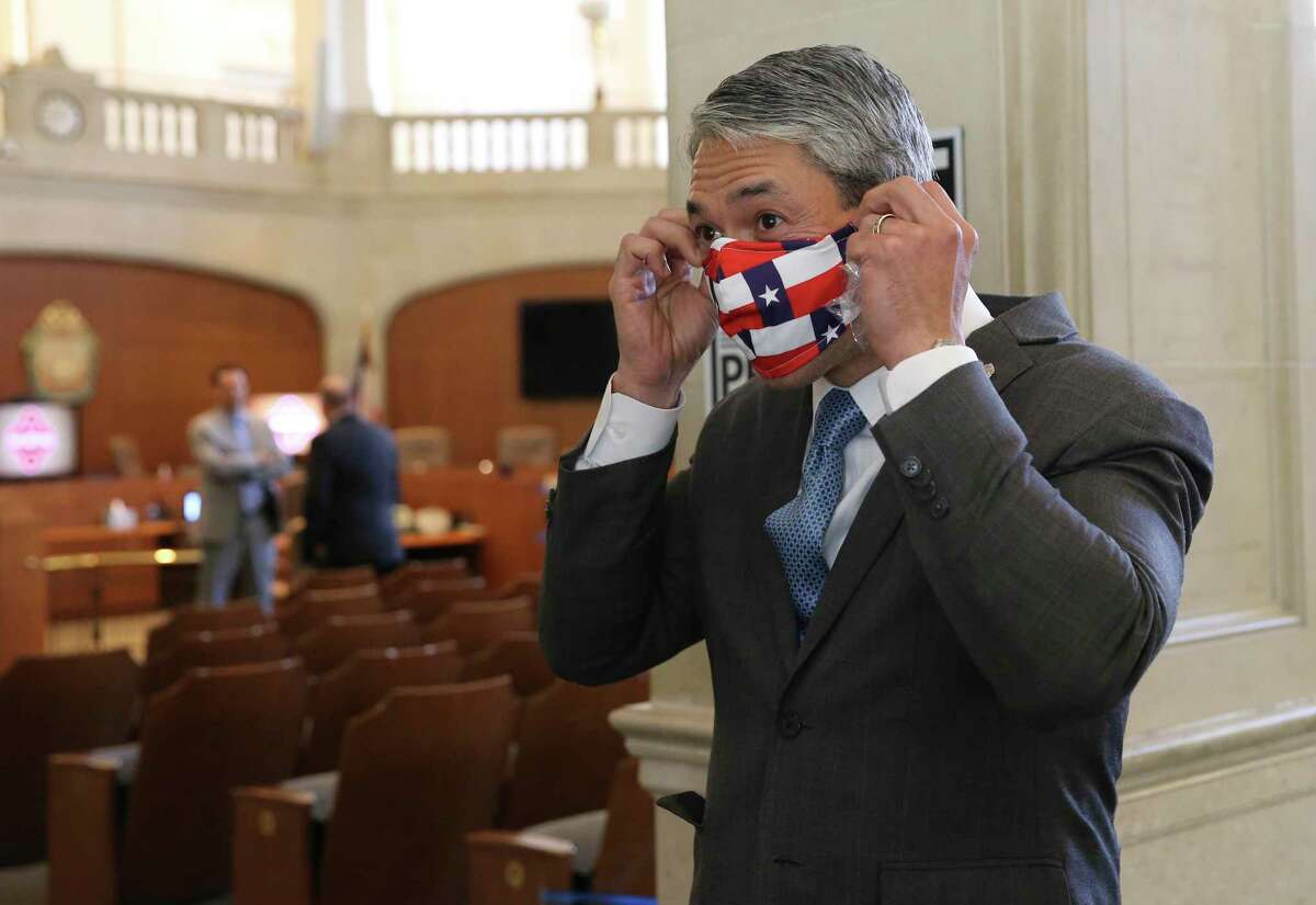 Mayor Ron Nirenberg puts on a mask after meeting with the press at the conclusion of the San Antonio City Council meeting on April 16. Nirenberg and County Judge Nelson Wolff have imposed a temporary curfew on social gatherings from 10 p.m. to 5 a.m. in public and private over the Thanksgiving holiday weekend.