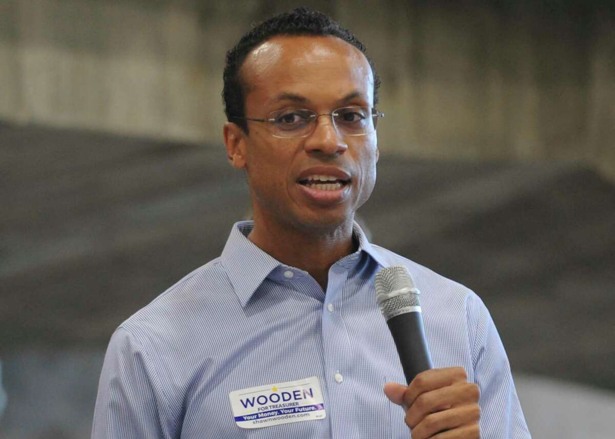 FILE -- In this Sunday, Sept. 16, 2018 file photo Shawn Wooden, then candidate for Connecticut state treasurer, speaks at the Greenwich Democratic Town Committee Cookout and Campaign Rally, in Greenwich, Conn. As treasurer, Wooden, who oversees $37 billion in public pension funds, announced plans Tuesday, Dec. 3, 2019 to reallocate $30 million worth of shares in civilian firearm manufacturer securities while banning similar future investments and creating incentives for banks and financial institutions to enact gun-related policies.(Tyler Sizemore/Hearst Connecticut Media via AP, File)