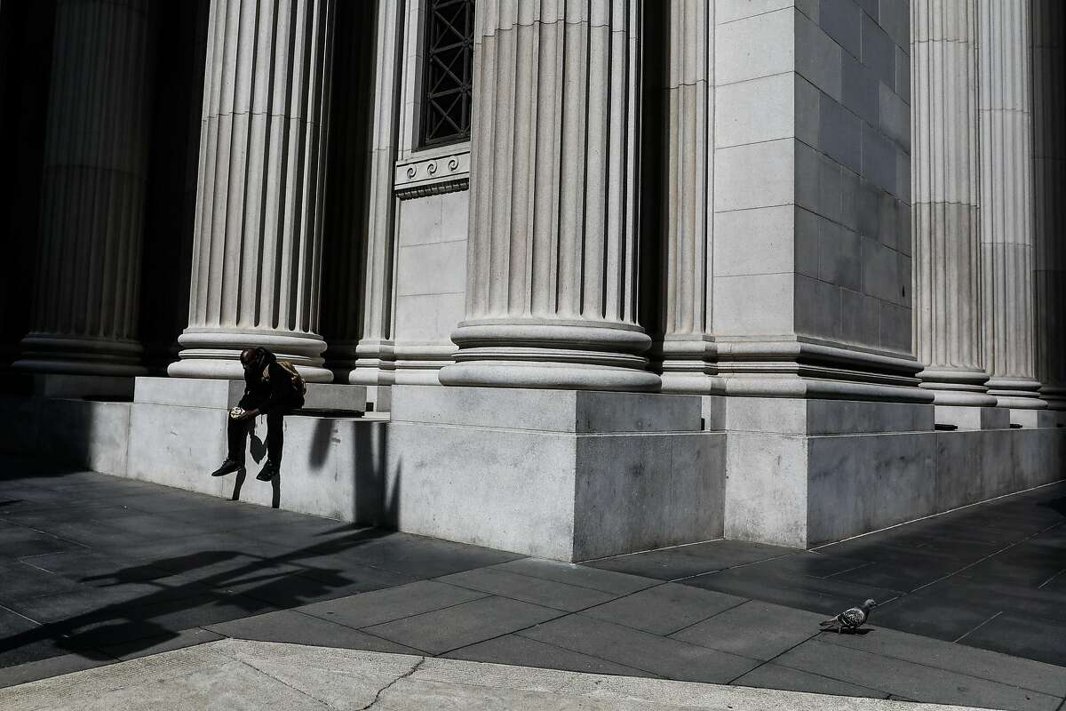 A person eats outside in the financial district on Tuesday, March 17, 2020 in San Francisco, California. The city is on lockdown due to the coronavirus.