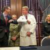 Texas Education Agency Commissioner Mike Morath, left, and Dr. David Fleeger, right, greet each other with an elbow touch before the start of a press conference on the coronavirus by Governor Greg Abbott at the Texas State Capitol in Austin, Texas on March 13, 2020. The vast majority of people recover from the new coronavirus. According to the World Health Organization, most people recover in about two to six weeks, depending on the severity of the illness. (Julia Robinson/The Dallas Morning News via AP)