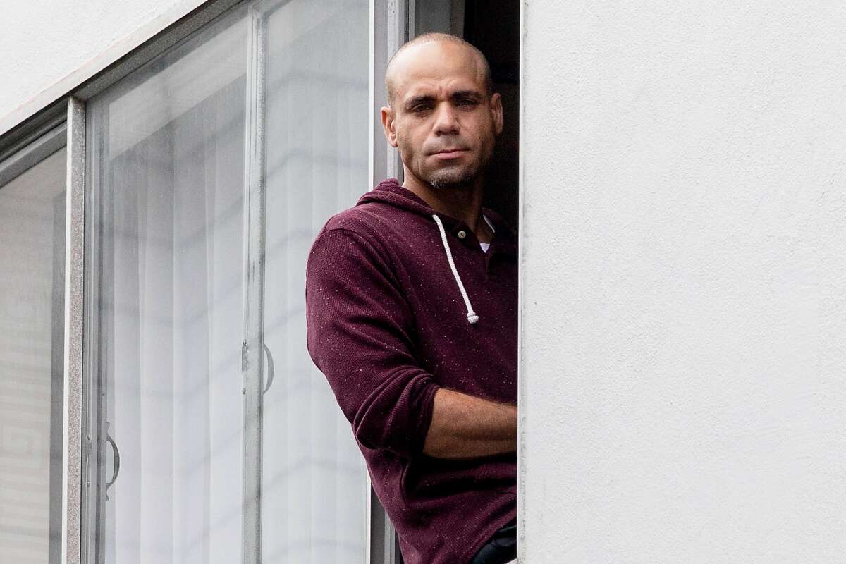 Darius Banks, 46, poses for a portrait in the window of his hotel room in San Francisco, Calif. Thursday, April 16, 2020. Thousands of homeless people are being moved out of shelters and streets and into leased hotel rooms during the Coronavirus outbreak.