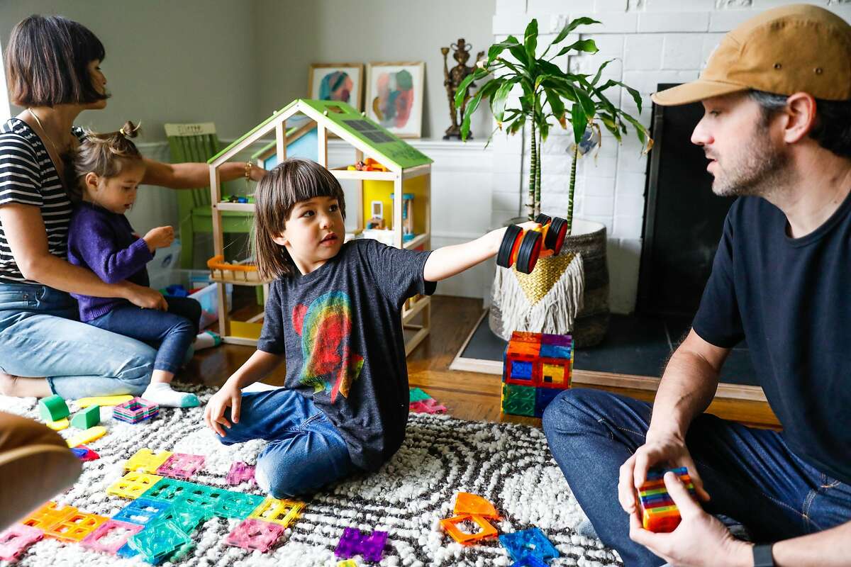 Jenny Seeger (left) and her husband Chad Seeger (right) play with their kids Eliette, 2, Graham, 4 (center) in their living room on Thursday, April 16, 2020 in San Francisco, California. Before the shelter in place took effect due the the coronavirus the Seeger�s used to only allow their children 30-minutes of screen time. Now that they are working from home in quarantine they�ve had to extend the use of iPad�s and television to several hours to get their work done.
