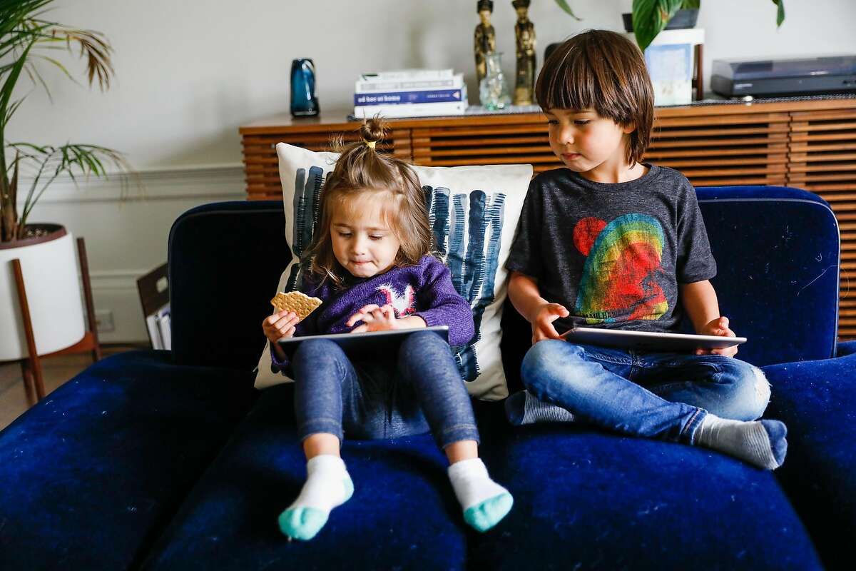 (L-r) Eliette Seeger, 2, and her brother Graham Seeger,4, relax on their iPads so that their parents can get work done on Thursday, April 16, 2020 in San Francisco, California. Before the shelter in place took effect due the the coronavirus the Seeger�s used to only allow their children 30-minutes of screen time. Now that they are working from home in quarantine they�ve had to extend the use of iPad�s and television to several hours to get their work done.