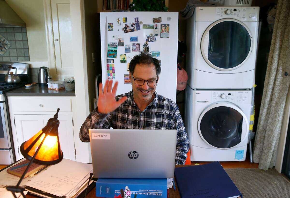 Will Cautero waves to Las Lomas High School students as they log in for an 11th grade English class conducted remotely from his home in Oakland, Calif. on Thursday, April 16, 2020.
