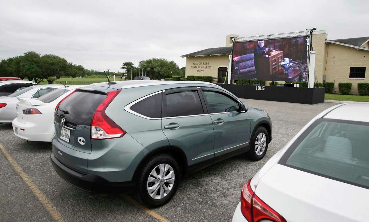 Mission Park Funeral Chapels South conducts a funeral service Friday with a large video screen displaying the services to mourners who stay in their cars in the parking lot.
