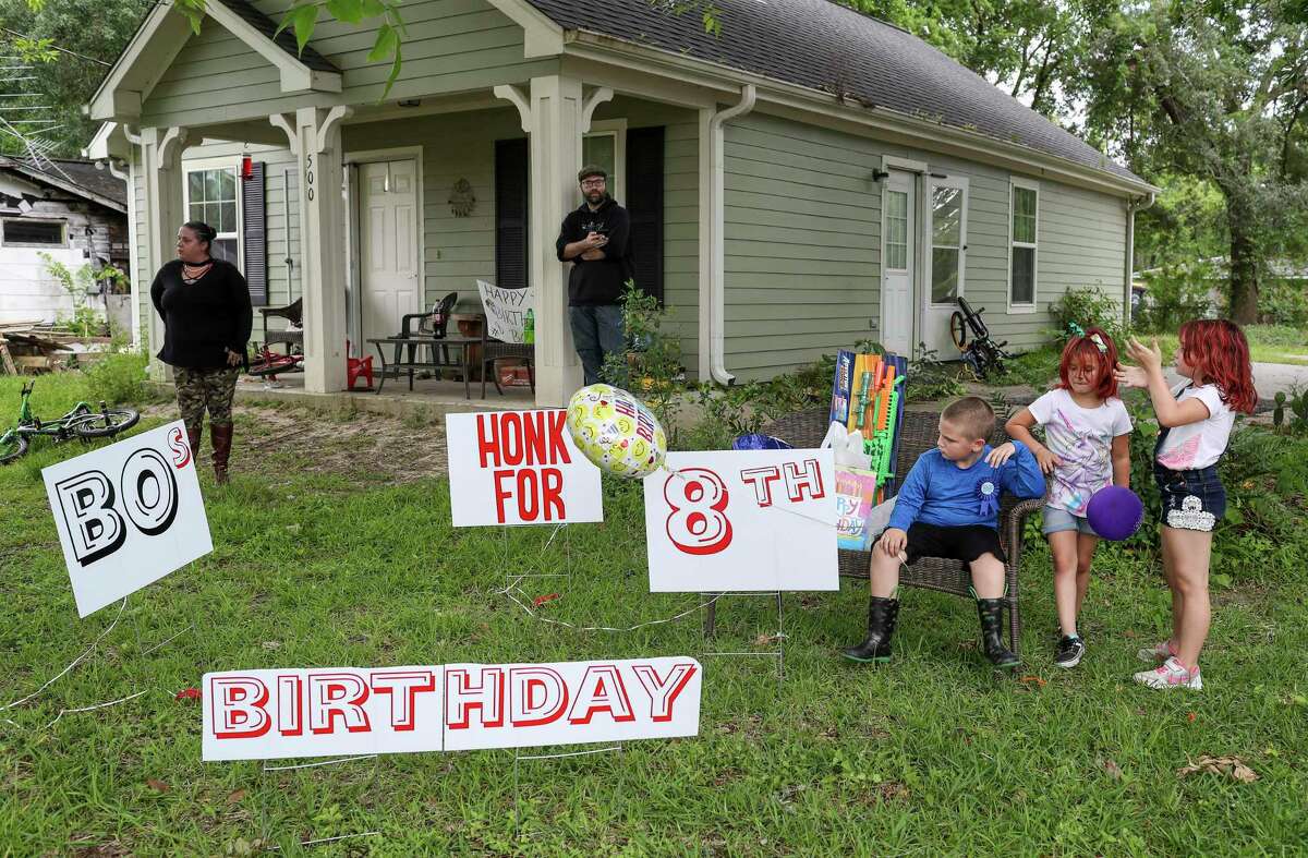 Bo Singleterry, front right, celebrates his eighth birthday with his cousins Brooke Crawford, 6, front center, and LeAnna Crawford, 7, front left, Friday, April 17, 2020, at his home in Anahuac. His parents had to cancel the birthday party sleep-over they had planned, but they arranged for a car parade to go by their house and honk for him.