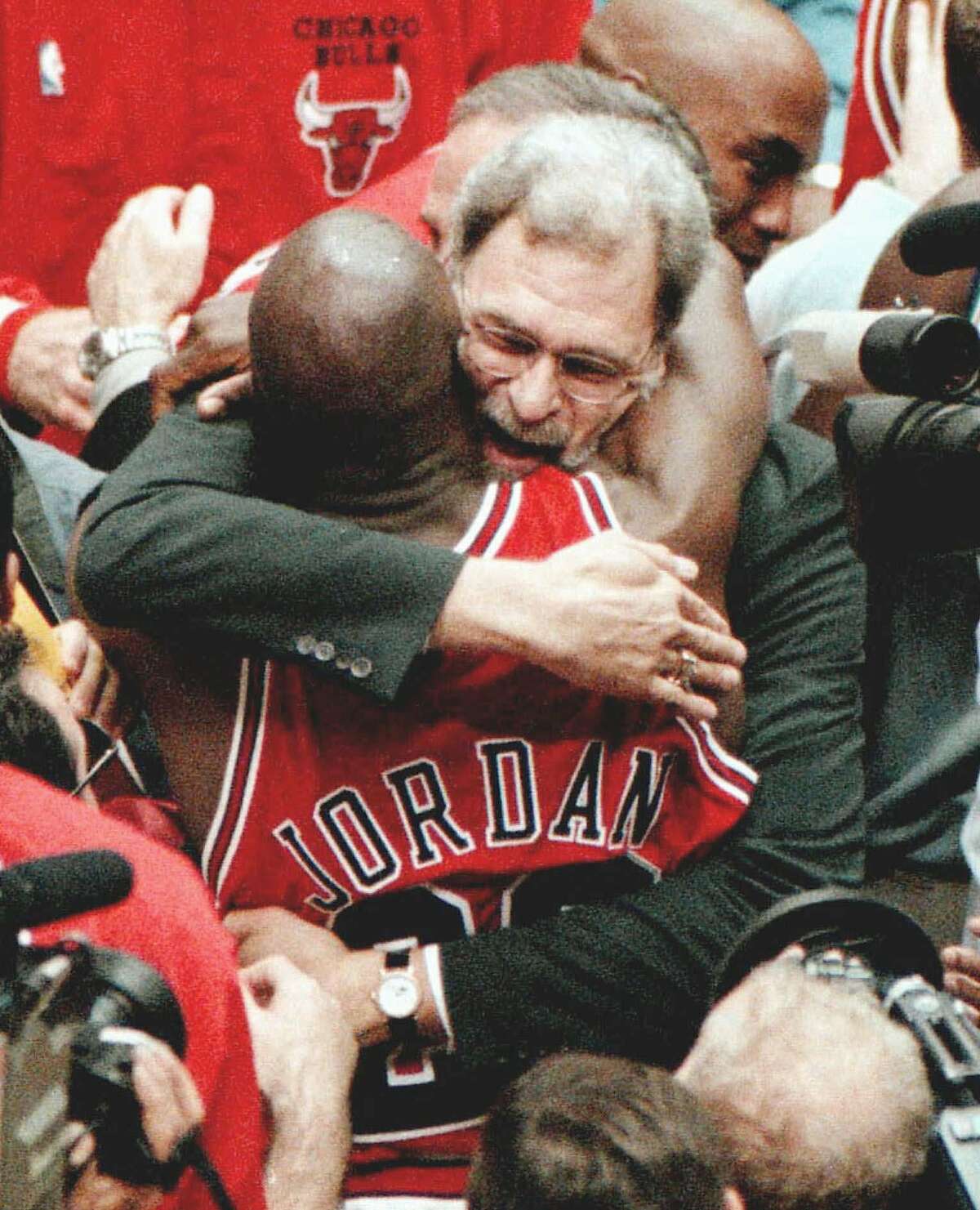 Chicago Bulls coach Phil Jackson and Michael Jordan embrace after the Bulls won their 6th NBA championship with an 87-86 win over the Utah Jazz in Game 6 on Sunday, June 14, 1998, at the Delta Center in Salt Lake City. (AP Photo/Chicago Tribune, Nuccio DiNuzzio) HOUCHRON CAPTION (06/16/1998): Michael Jordan would love to see Phil Jackson return, but don't count on it.