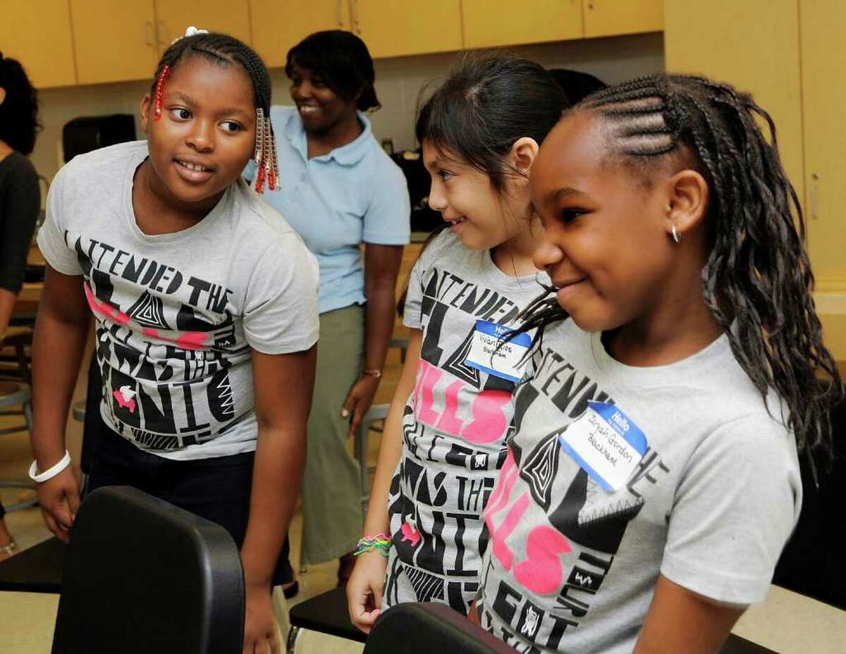 L to R: Mykeya Turner, 9, Vivian Rios, 9, and Zaryah Gordon, 8, dance to a music presentation at the Jettie Tisdale School in Bridgeport, CT on Friday August 20, 2010. Bridgeport schoolchildren with perfect attendance were treated to a morning full of fun, including music, a visit to the Bridgeport Public Library bookmobile, and congratulations from Superintendent John J. Ramos.