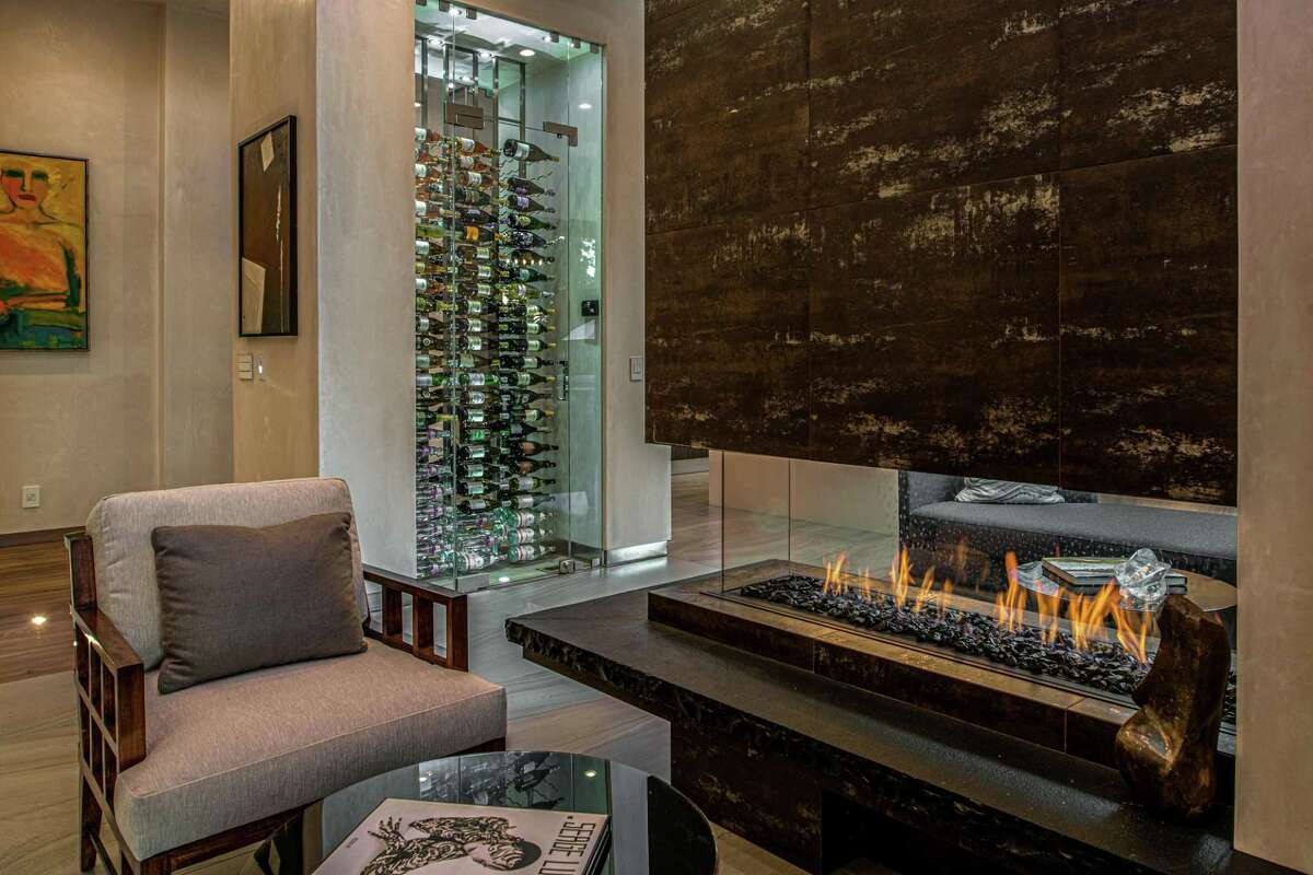 The Carmel estate home includes a temperature-controlled wine room beside a floating gas fireplace.