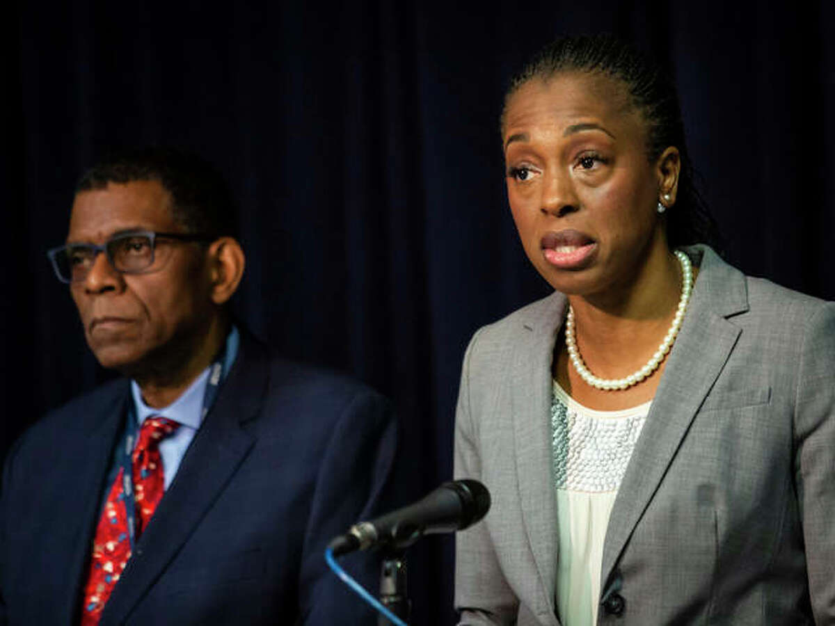 Dr. Terry Mason, left, chief operating officer of the Cook County Department of Public Health, looks on as Dr. Ngozi Ezike, right, director of the Illinois Department of Public Health, discusses the second confirmed case of a new virus in Illinois during a press conference at the Thompson Center, Thursday, Jan. 30, 2020, in Chicago. Health officials are reporting the first U.S. case of person-to-person spread of the new virus from China. The latest patient is the husband of the Chicago woman who got sick after she returned from a trip to China.