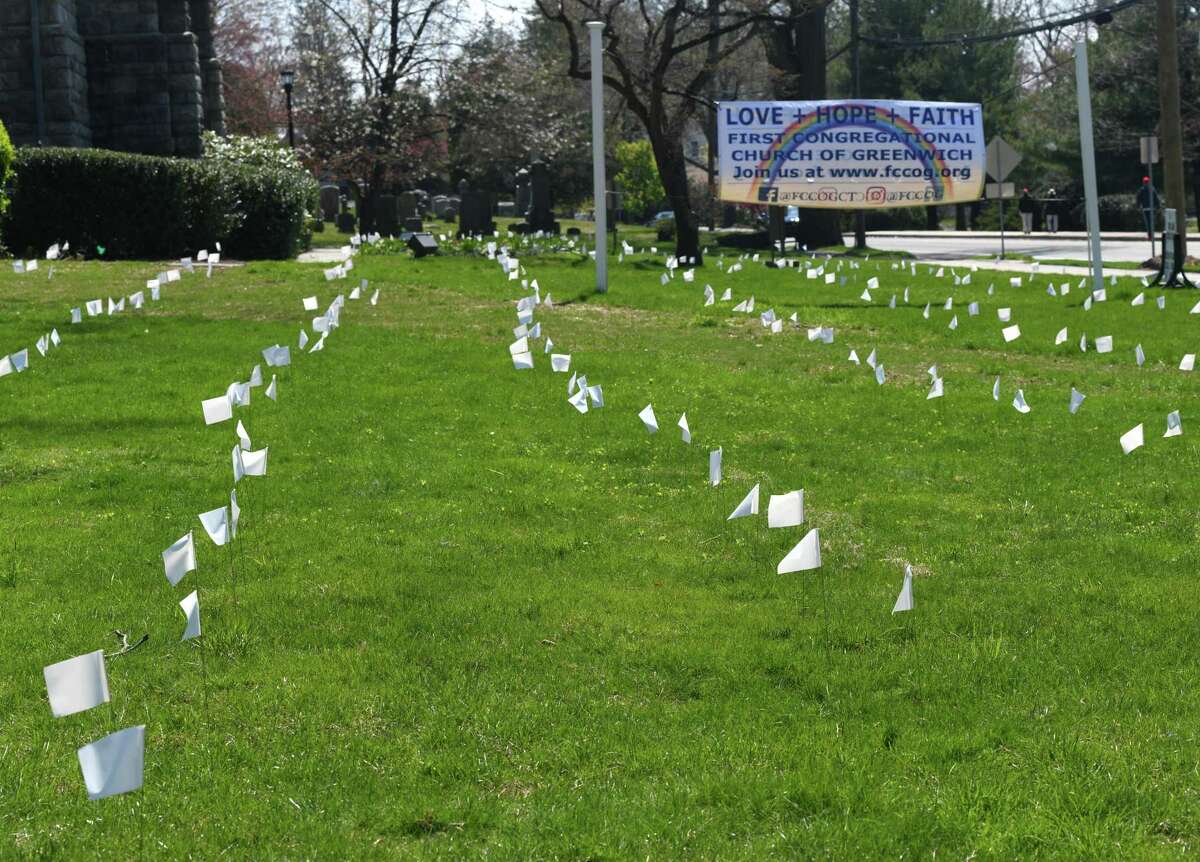 Hundreds of while flags are displayed in memory of the lives lost to COVID-19 in Connecticut at First Congregational Church of Greenwich in Old Greenwich, Conn. Sunday, April 19, 2020.