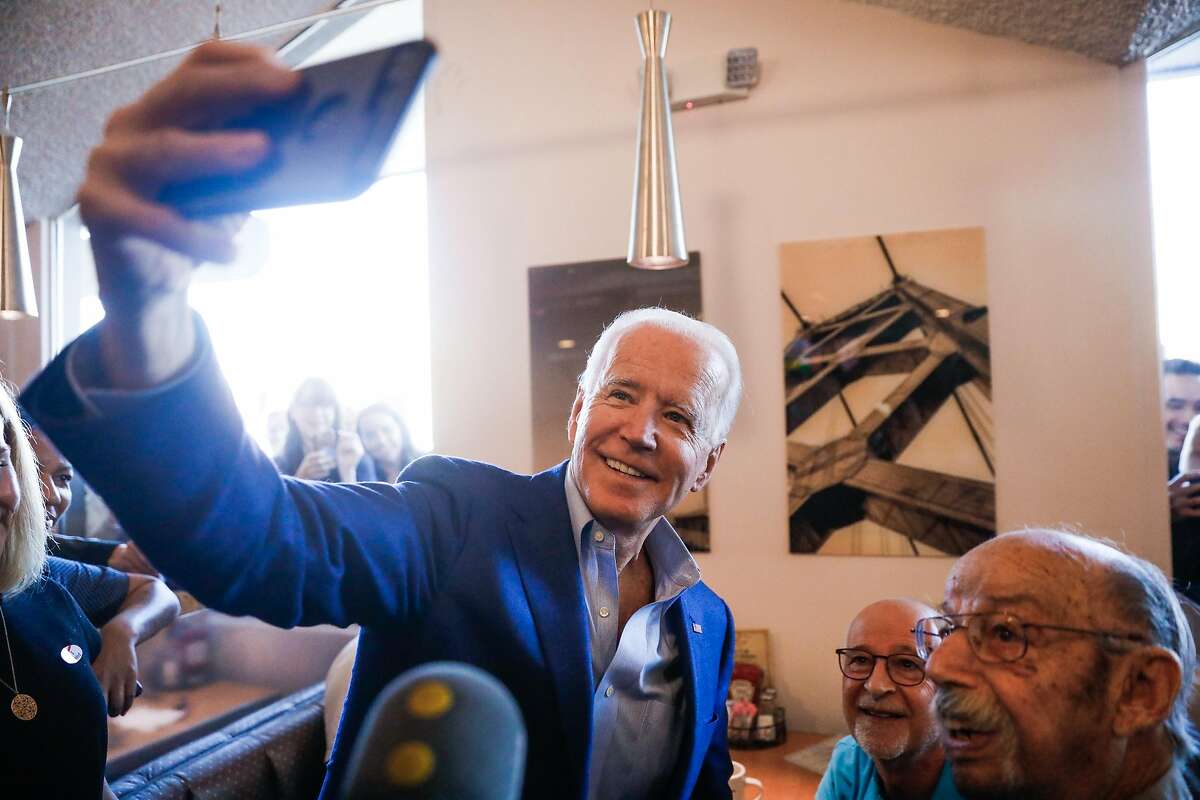 Democratic presidential candidate and former Vice President Joe Biden takes a selfie with a patron at Buttercup diner on March 03, 2020 in Oakland, California.