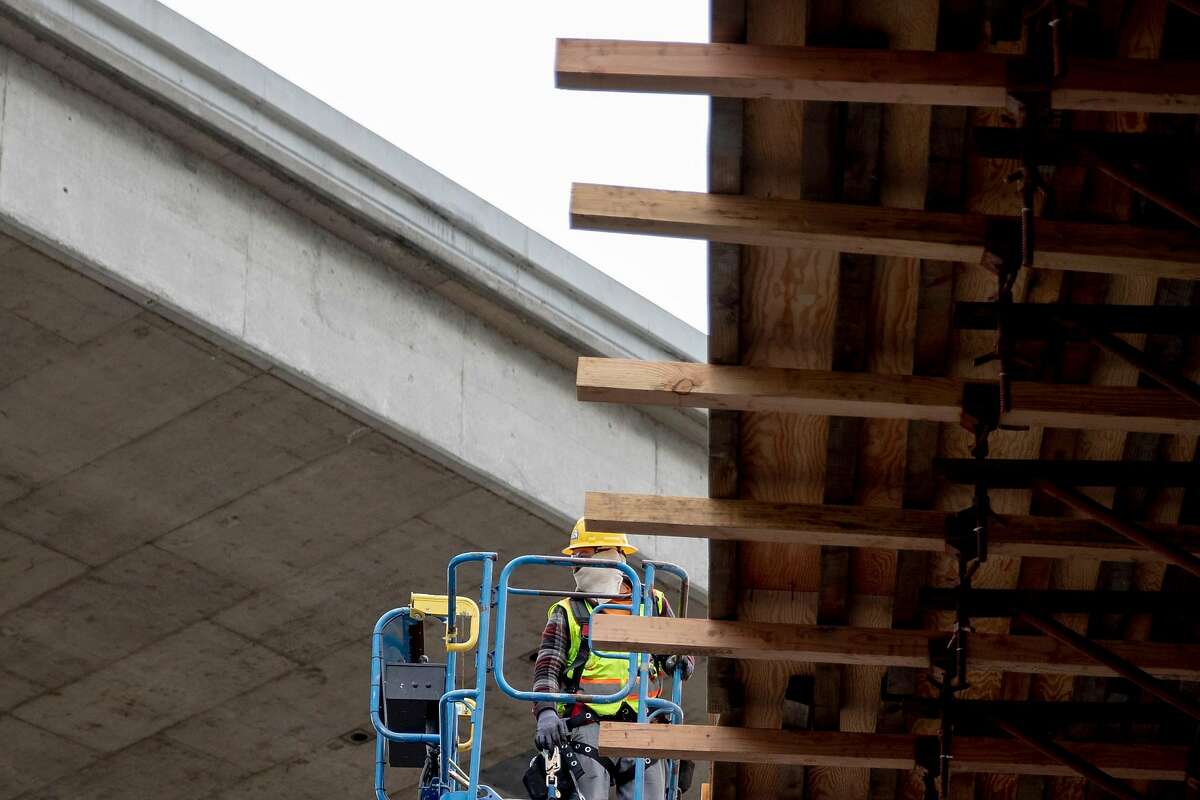 Construction workers build scaffolding and work areas ahead of a large project near Alemany Boulevard along Highway 101 northbound in San Francisco, Calif. Friday, April 17, 2020. Caltrans is taking advantage of unusually light shelter in place traffic to speed up some transportation projects. Among the biggest is the Alemany project, which will replace 800 feet of crumbling concrete deck slabs near the 101/280 interchange.
