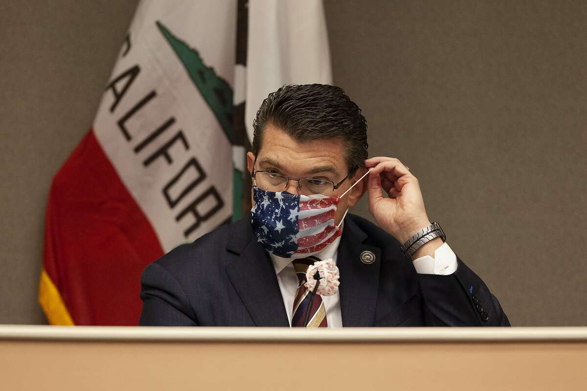 Assemblyman Jay Obernolte, R-Big Bear Lake, vice chair of the Assembly budget committee, puts on a mask before the start of an oversight hearing of the Assembly budget special subcommittee on COVID-19 at the Capitol in Sacramento, Calif., Monday, April 20, 2020. Lawmakers are looking into how California Gov. Gavin Newsom has been spending money to address the new coronavirus crisis. (AP Photo/Rich Pedroncelli, Pool)