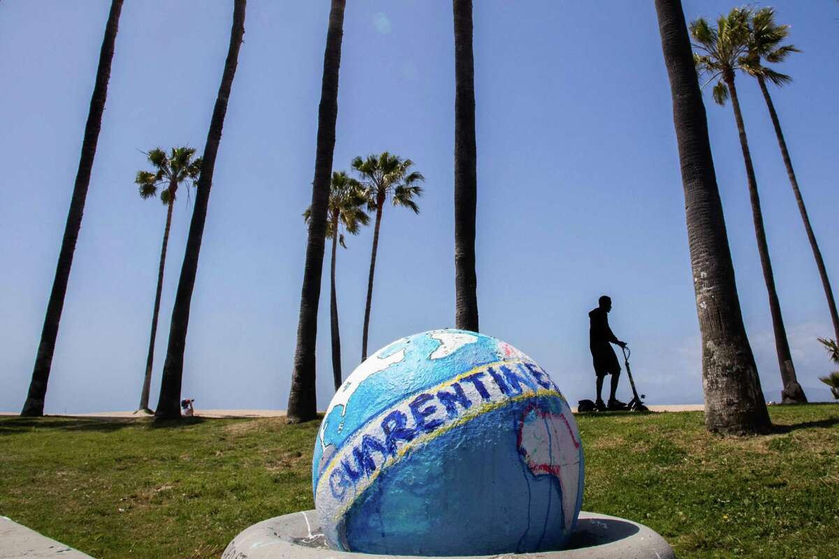 A man rides his scooter past a sculpture of a quarantined earth in Venice Beach earlier this month. With the nation in quarantine, the U.S. could be learning valuable environmental lessons for the future.