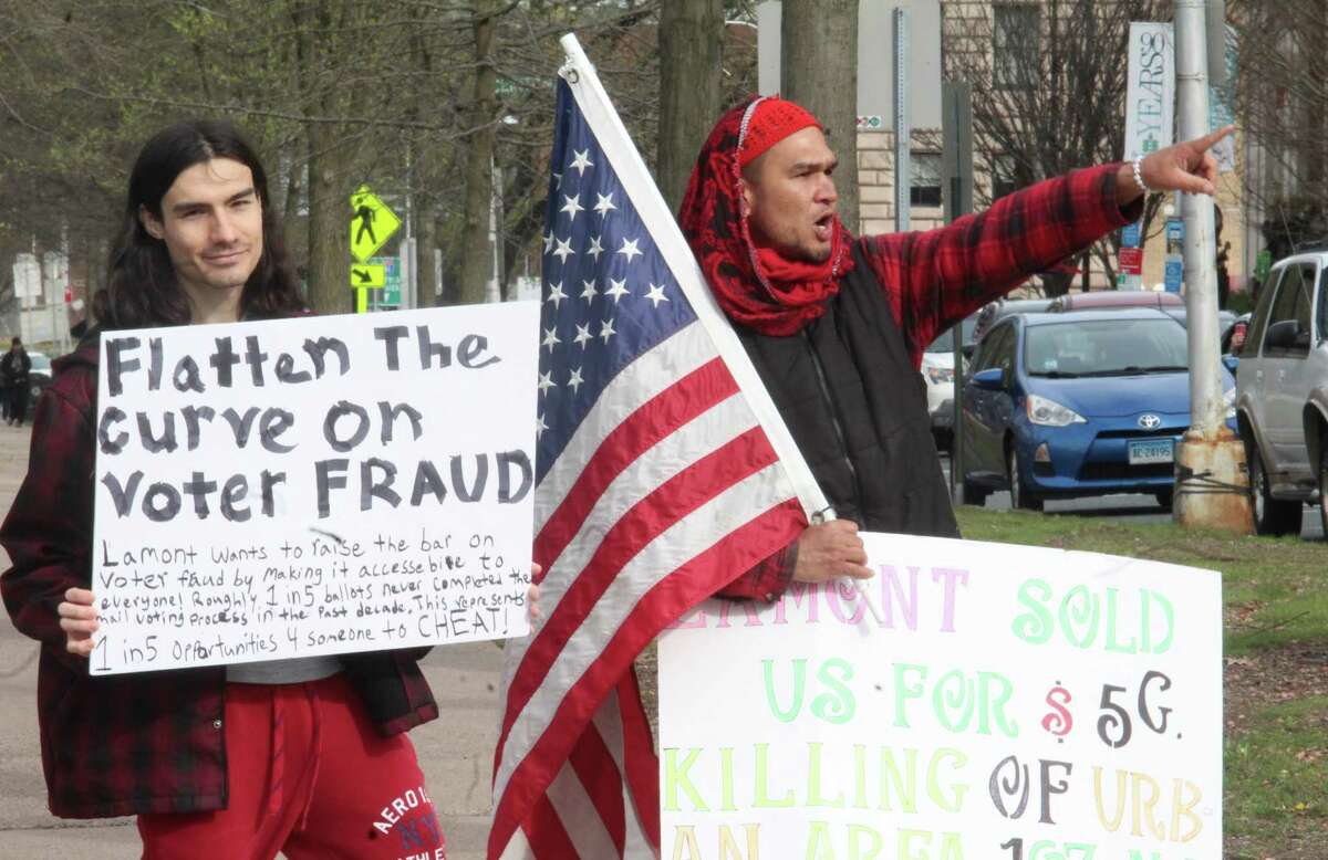 More than 1,000 people in about 300 vehicles circled the state Capitol and later the governor's residence in Hartford Monday, April 20, 2020, to protest the shutdown of the state for coronavirus. Many showed signs and wore hats and t-shirts in support of President Donald Trump. One lone counter-protester stood with a mask, and declined to give her name.