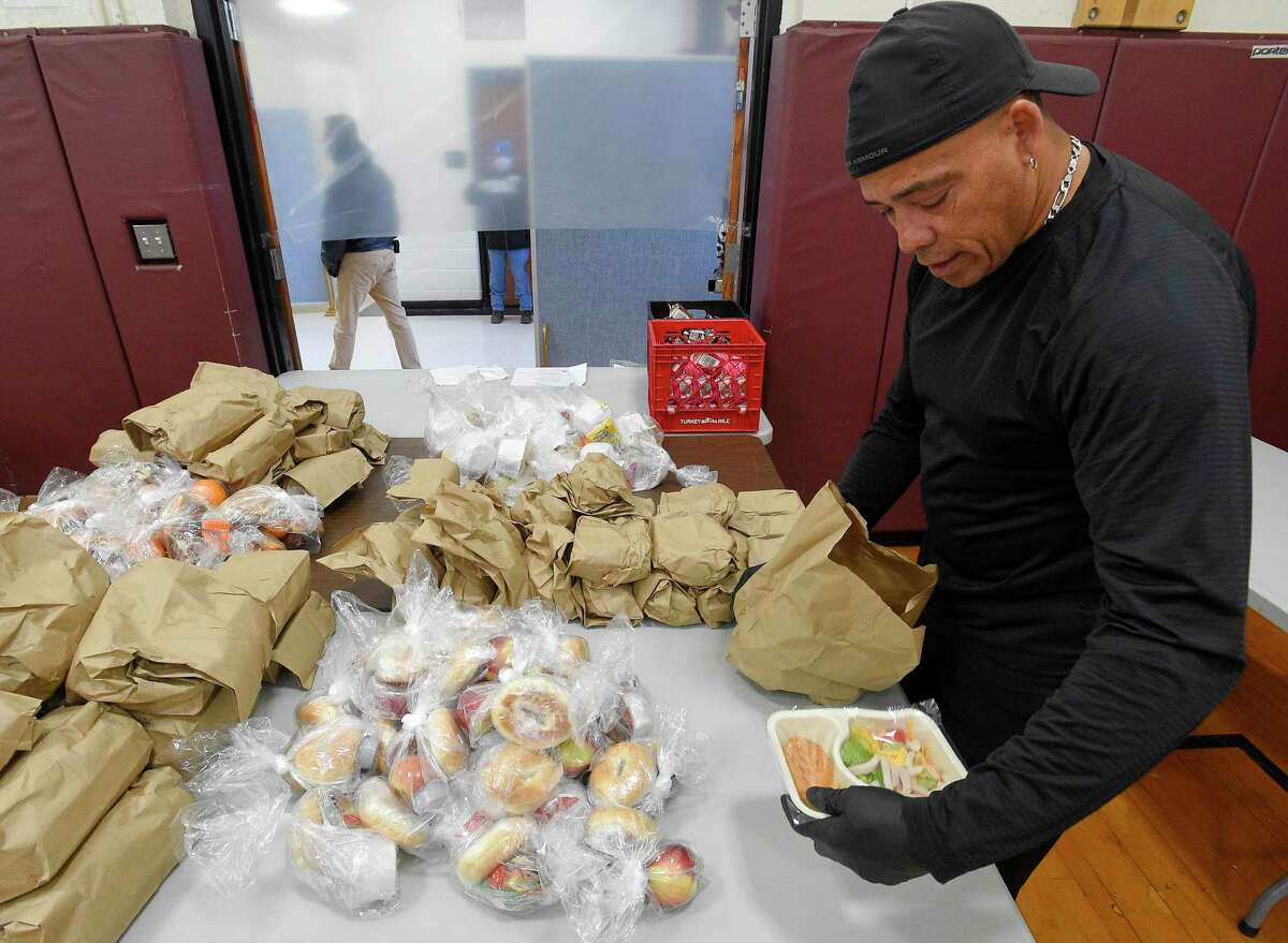 Volunteer P.J. Johns checks the contents of a meal that is being handed out to families on Friday, April 17, 2020 in Stamford, Connecticut. As part of the Grab and Go Meals that Stamford Schools is providing to families, Johns, a resident of Darien is volunteering with a Norwalk based non profit Filling in the Blanks, helping supplement Stamford Schools Grab and Go Meal plan, ensuring no child goes hungry while schools are closed. Over 500 volunteers have partnered with the City of Stamford's citywide Stamford Together program to help support emergency response efforts related to the COVID-19 public health emergency. Volunteers step up to help in food distribution, testing site check in's and other areas throughout the city and Fairfield County.