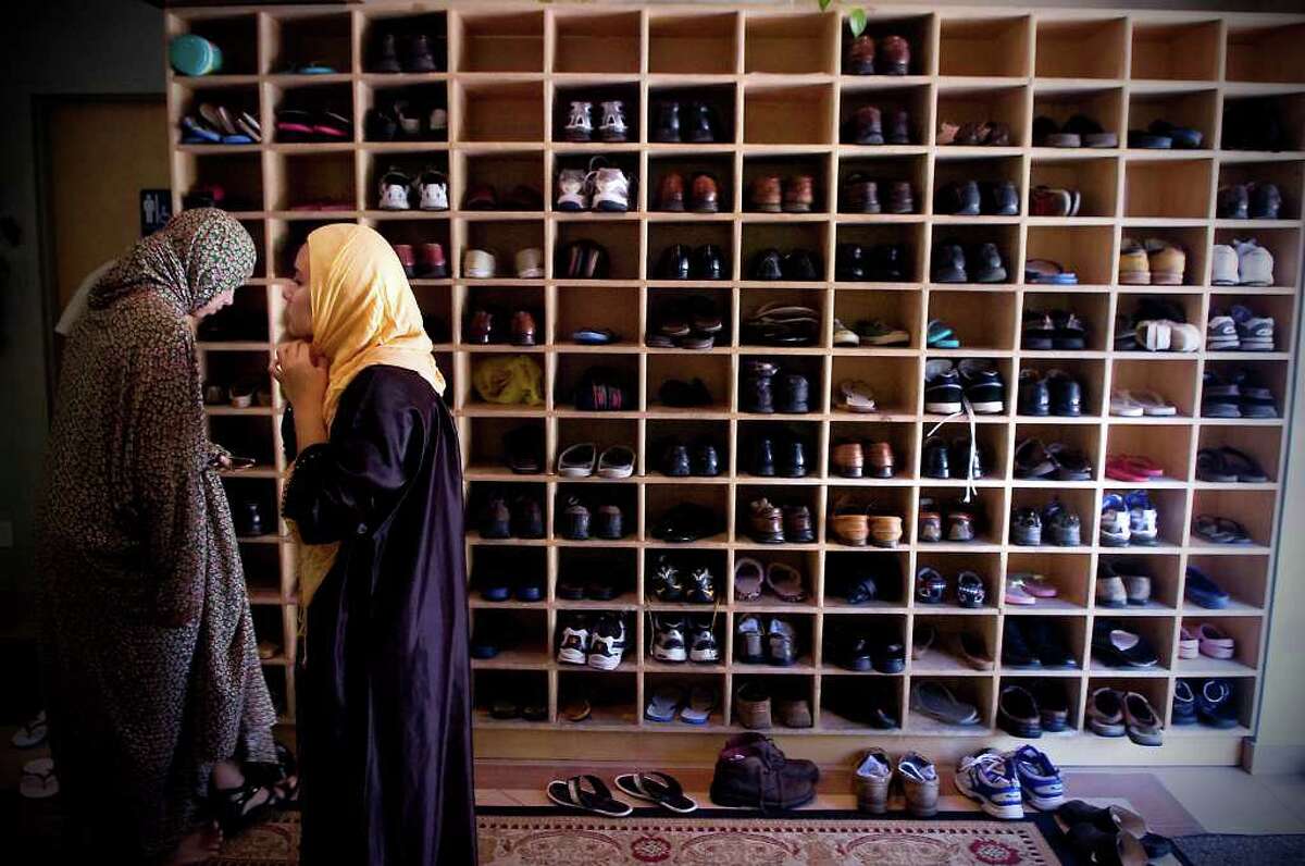 Women remove their shoes as they arrive at the Stamford location of The Islamic Cultural Center of New York to participate in afternoon prayer in Stamford, Conn. on Friday August 20, 2010.