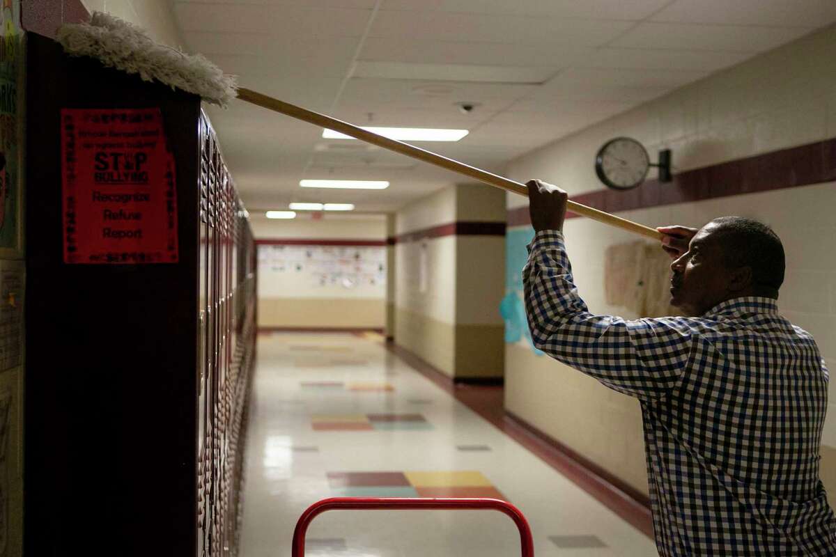 Northside ISD custodial supervisor Kenneth Timbers cleans lockers during Spring Break at Dolph Briscoe Middle School. Days later, schools were closed in response to the coronavirus pandemic, and have not reopened. The economic damage to the state has school superintendents worried about serious funding cuts as they try to plan budgets for next school year.