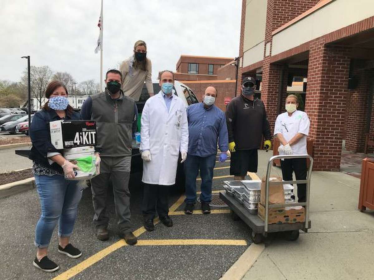 Helping Hands for Heroes (www.helpinghandsforheros.com) in New Milford has provided personal protective equipment and food to various groups and the community and beyond in recent weeks during the coronavirus pandemic. Above, Joe Quaranta, second from left, who heads up Helping Hands, is shown with hospital staff and Dino Kolistas, owner of two restaurants in New Milford, third from right, during a recent delivery of food to the hospital for the staff.
