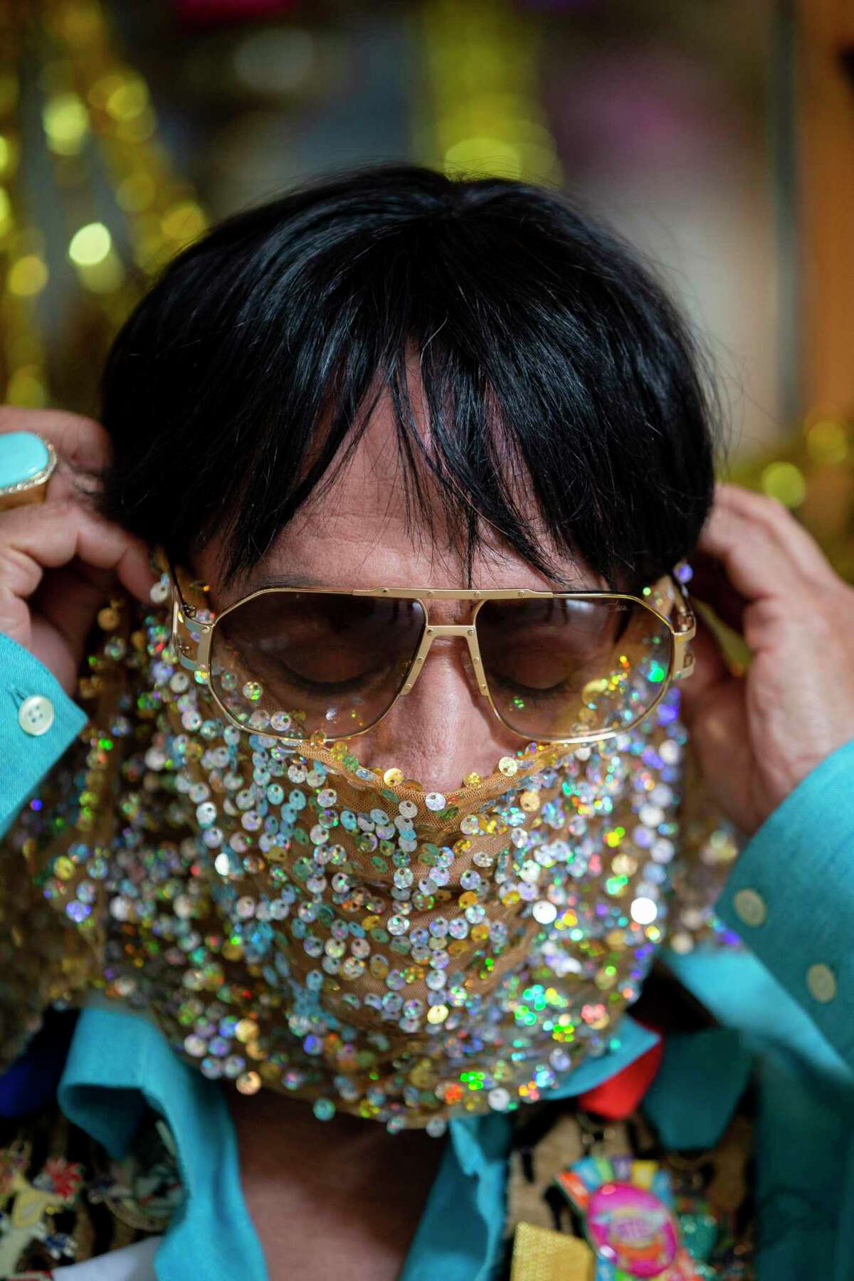 Karlos Anzoategui puts on a sequined scarf as a mask at his home. He has decided to celebrate Fiesta at home in his own ways. "I will not let COVID-19 take the Fiesta out of my life," he says. "Keep going, keep moving, keep doing!"