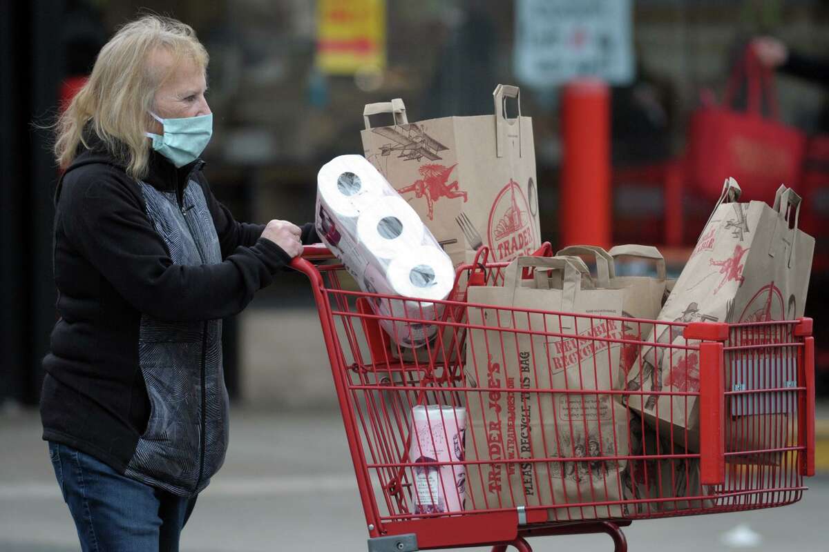 A shopper exits Trader Joe’s, in Orange, Conn. April 21, 2020. In a recent episode of its podcast, Trader Joe's explained why it hasn't added curbside pickup or delivery to its store offerings during the coronavirus pandemic.