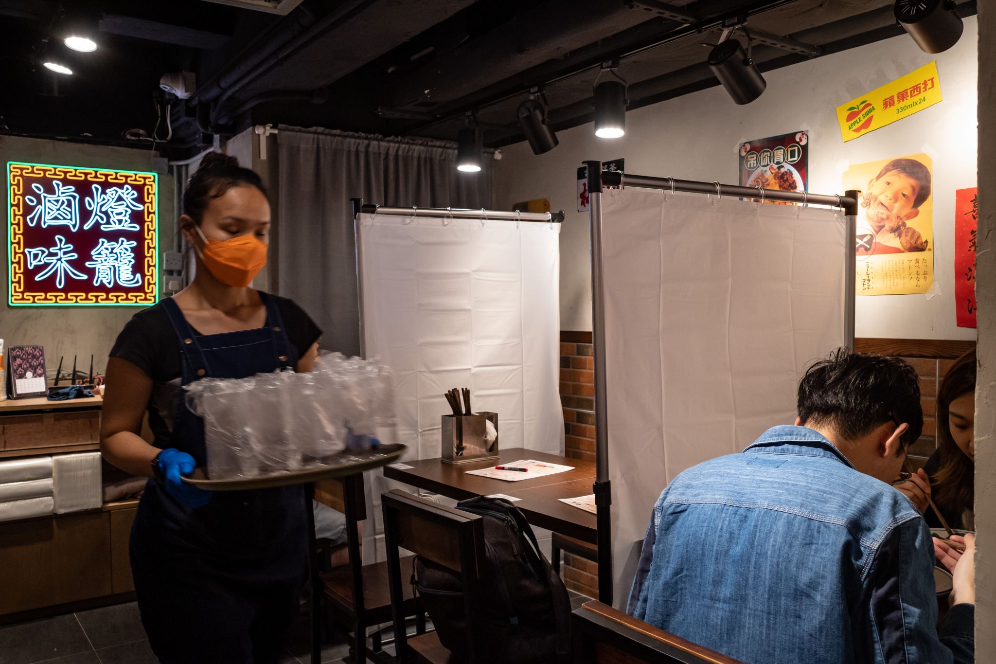 Partitions between seating areas Partitions are being installed between tables at some restaurants, including this one in Hong Kong, much like the Plexiglass that is being installed in places around the United States such as at checkstands in grocery stores. Shown: Customers eat in a restaurant with plastic screens to make sure people adhere to social distancing on March 28, 2020 in Hong Kong.