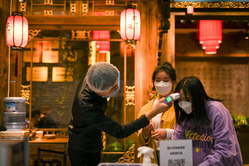 Temperature checks Temperature checks have become part of the routine before entering a restaurant. Here, a customer registers as a staff member checks her body temperature at the entrance of a restaurant in Chengdu, southwest China's Sichuan Province on March 21, 2020.
