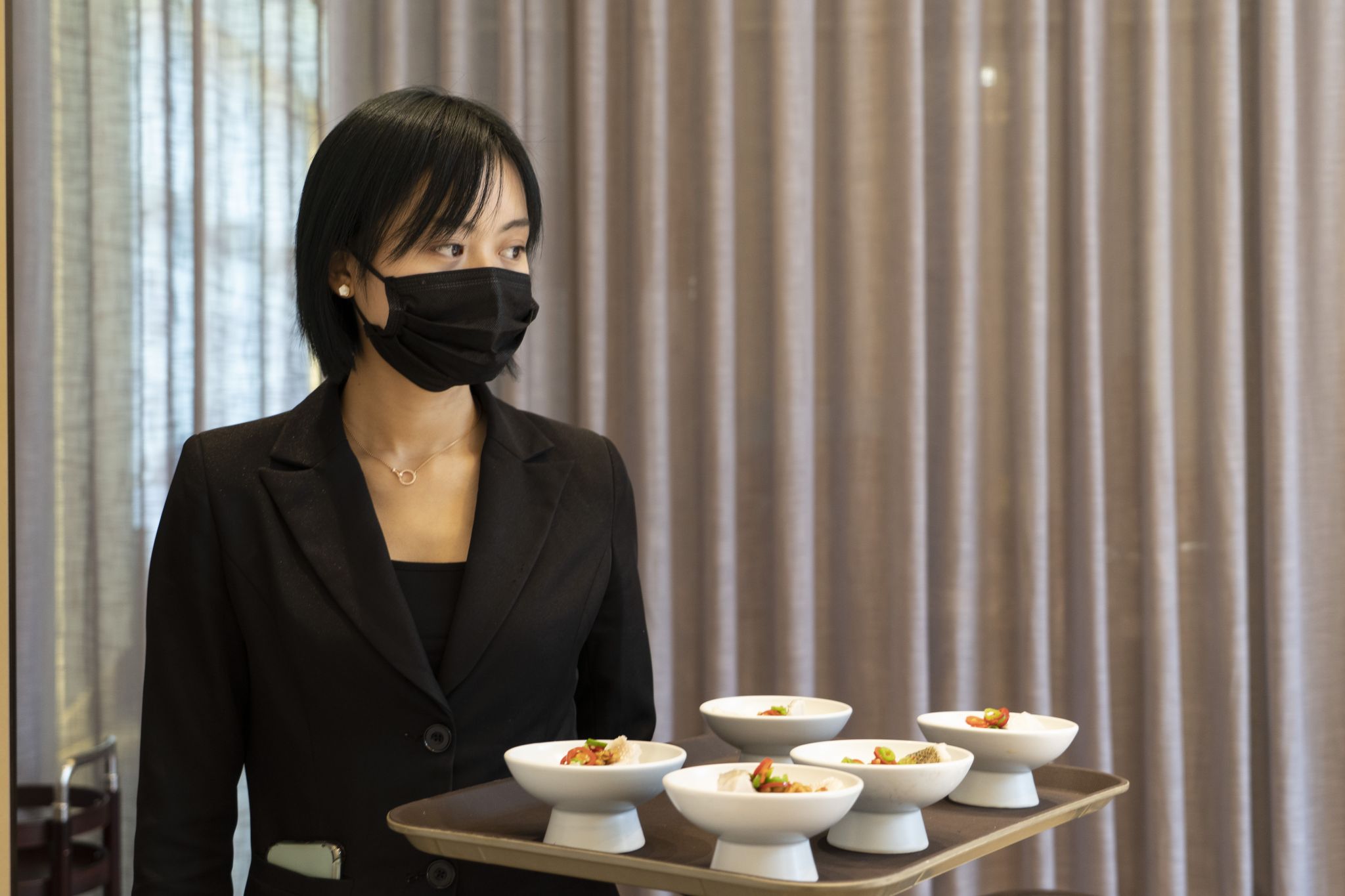 Restaurant employees wearing masks Employees at restaurants are required to wear masks, including servers like this one. Customers are required to wear masks unless they are eating and drinking, according to the Associated Press. Shown: A waitress serves separate dishes to customers at a restaurant in Chengdu, capital of southwest China's Sichuan Province, April 15, 2020.