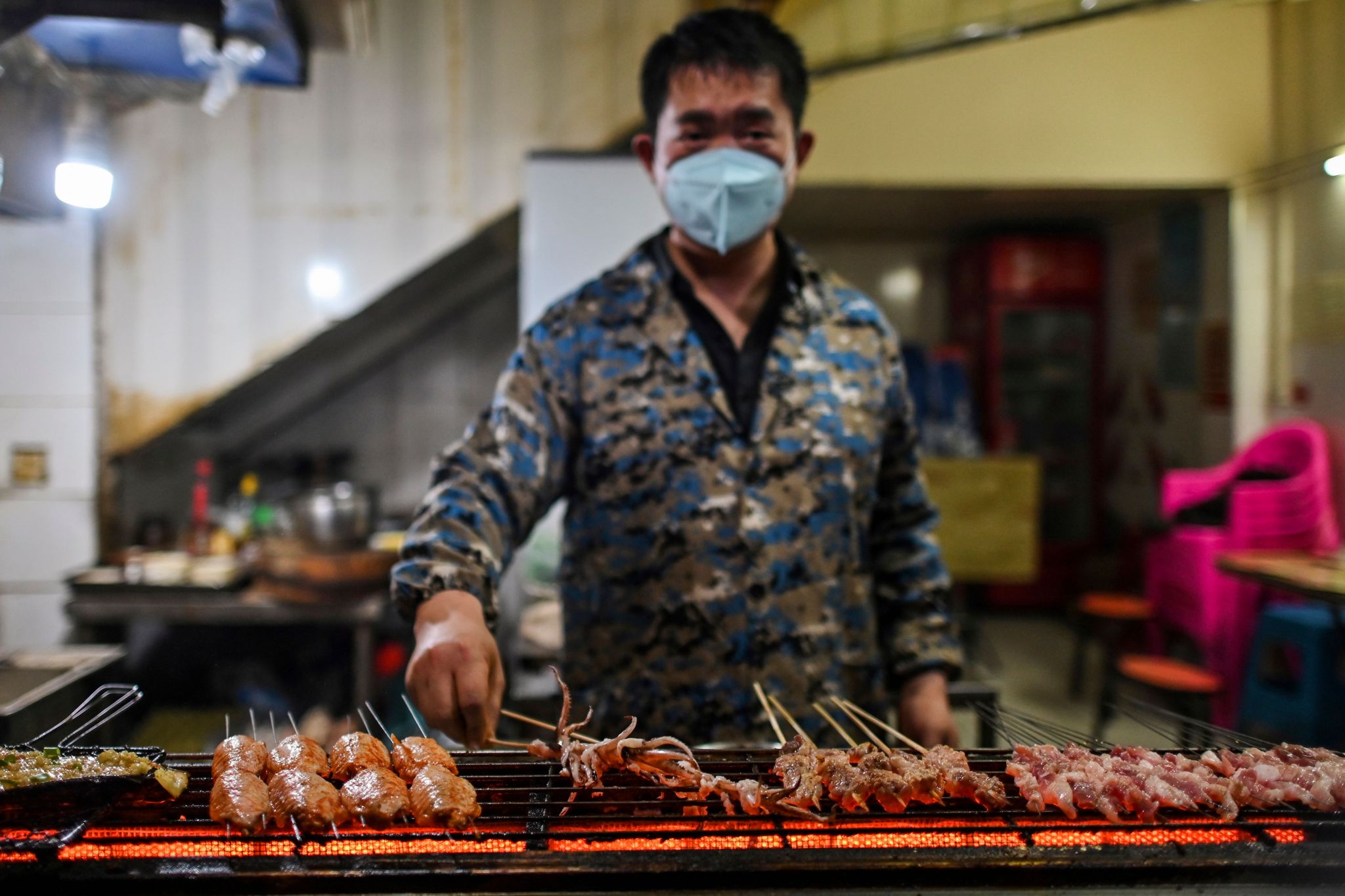A man prepares barbecue in a restaurant in Wuhan, in China's central Hubei province on April 16, 2020.