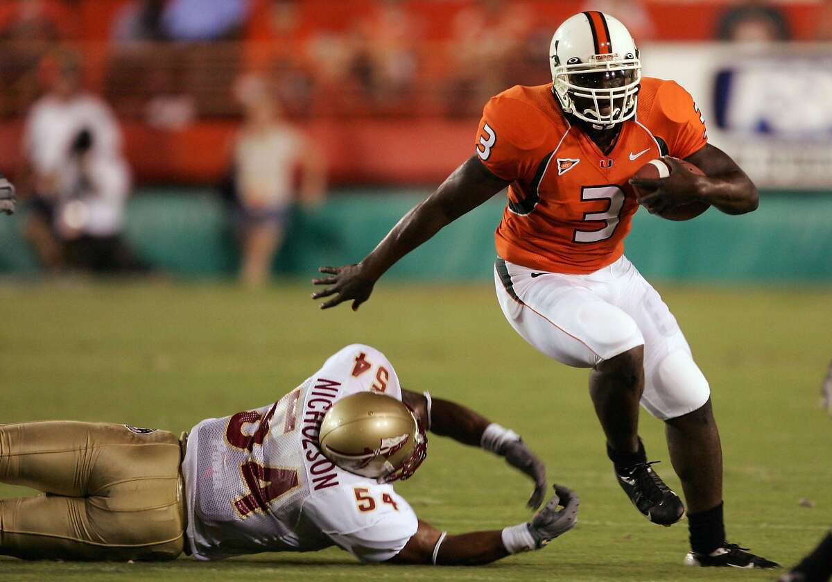 MIAMI - SEPTEMBER 10: Frank Gore #3 of the University of Miami Hurricanes runs with the ball as A.J. Nicholson #54 of the Florida State Seminoles tries to block him in the first half on September 10, 2004 at the Orange Bowl Stadium in Miami, Florida. ~~