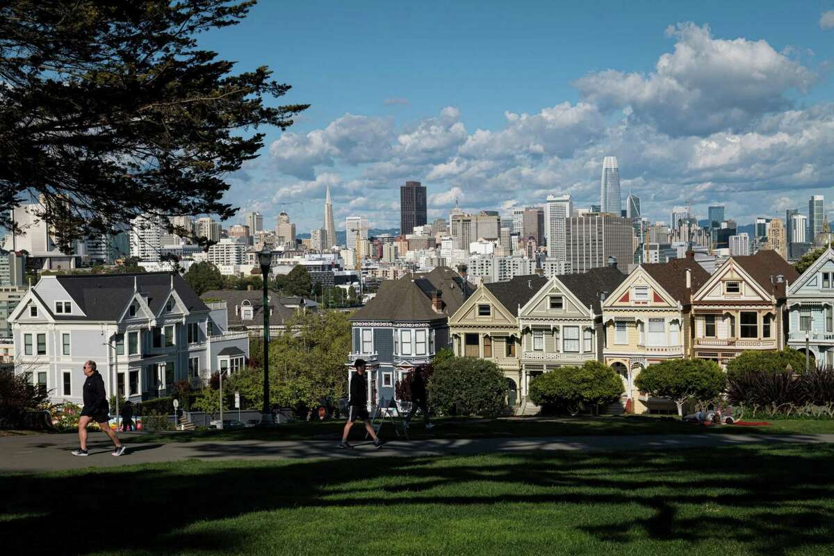 People walk along a path at Alamo Square in San Francisco on March 26, 2020.