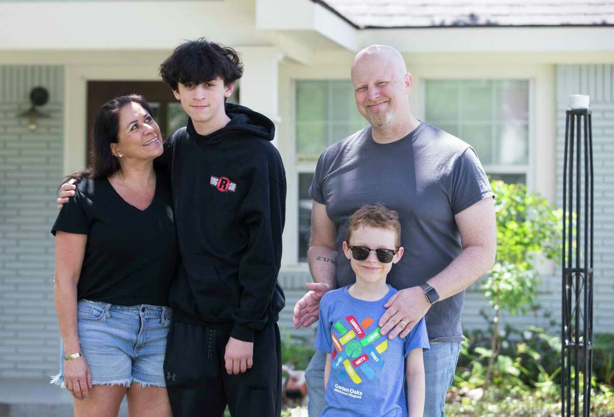 A portrait of Sylvia Escobedo, 50, from left, her son, Luke Newman, 14, her ex-husband, Murray Newman, 47, and his younger son, Smith Newman, 6, when Newman is picking up Luke for a week at Escobedo's house Wednesday, April 15, 2020, at Garden Oaks in Houston. Newman and Sylvia Escobedo have modified the custody of Luke by alternating weeks during the coronavirus, and both have found the process to be as smooth as it has before the pandemic. Before the pandemic, Newman almost sees Luke everyday while Luke lives with Escobedo.