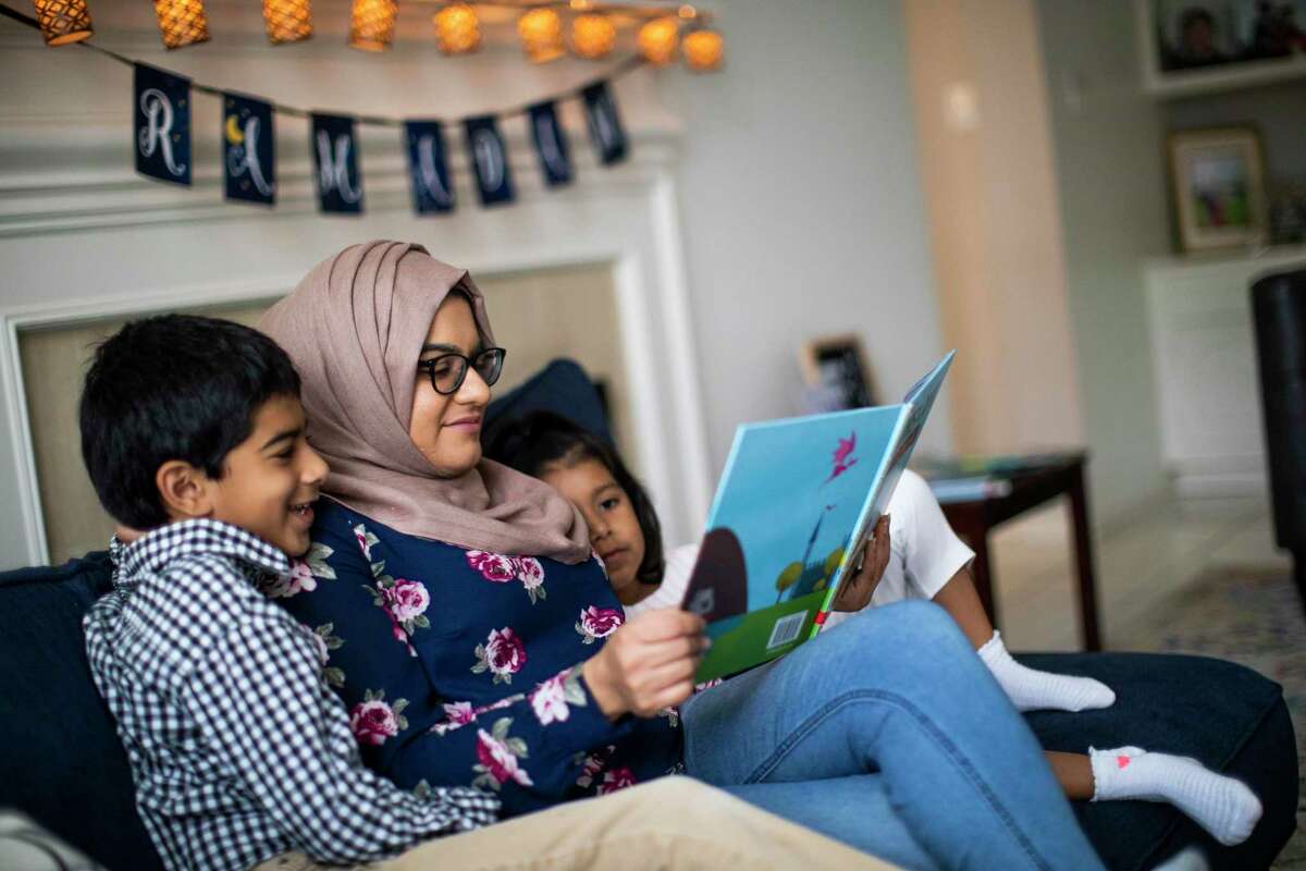 Mariam Zakaria, 30, reads to her nephew Adam Zakaria, 7, and her niece Alia Zakaria, 5, the book titled Ilyas and Duck in a Zakat Tale: A Story about Giving ahead of Ramadan on Wednesday, April 22, 2020, in Sugar Land.