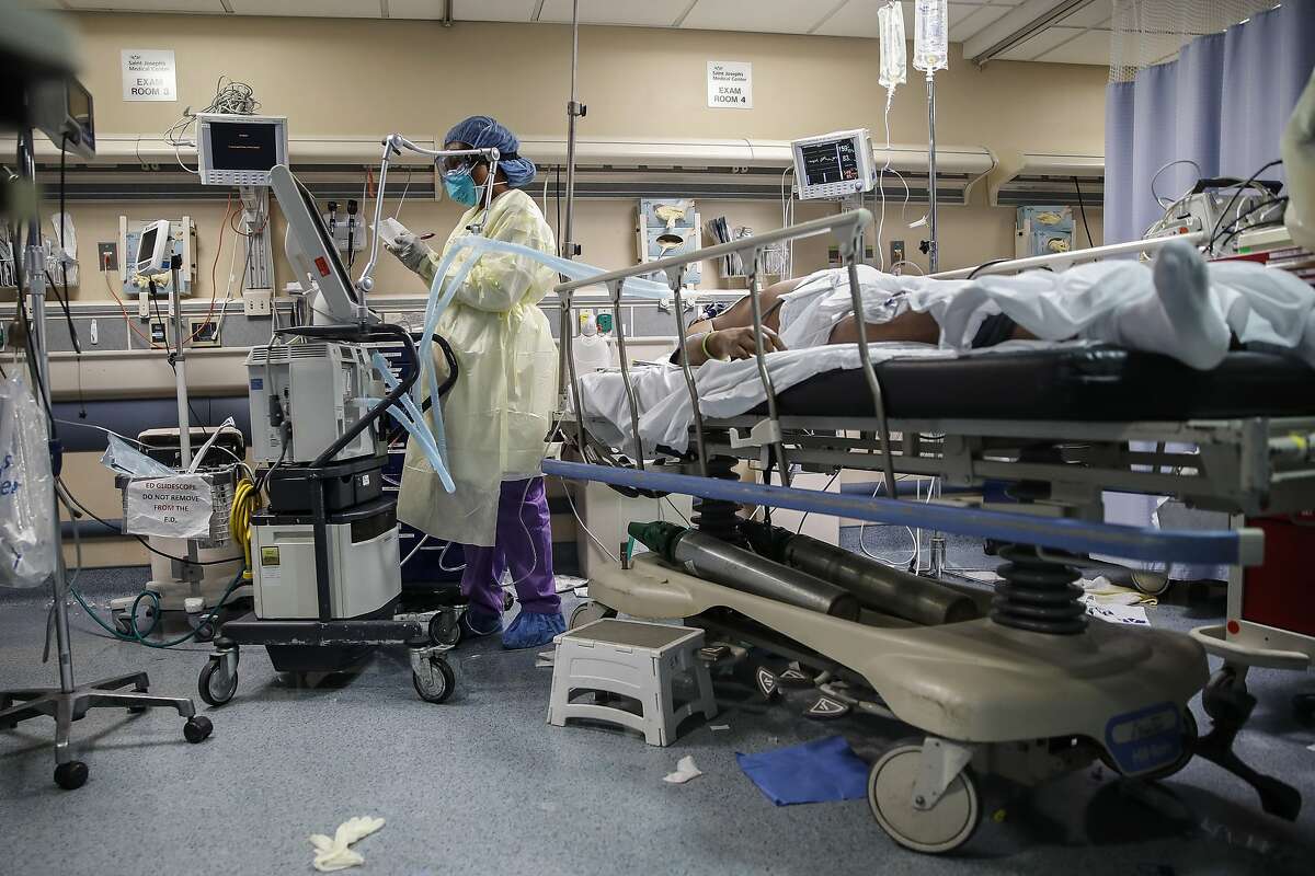 A nurse operates a ventilator for a patient with COVID-19 who went into cardiac arrest and was revived by staff, Monday, April 20, 2020, at St. Joseph's Hospital in Yonkers, N.Y. (AP Photo/John Minchillo)
