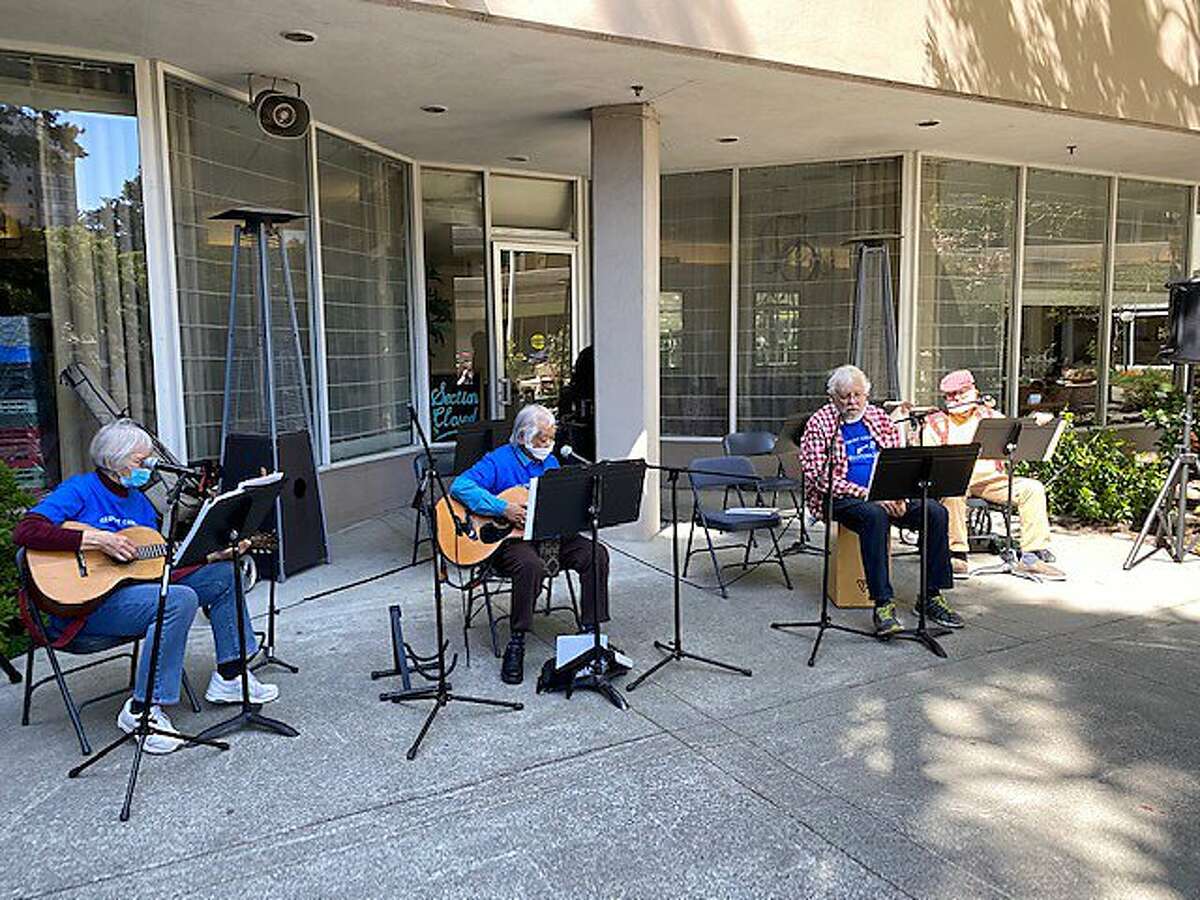 Hootenanny Club, in courtyard, leads senior singalong for residents on the balconies above at 16-story Piedmont Gardens senior complex in Oakland