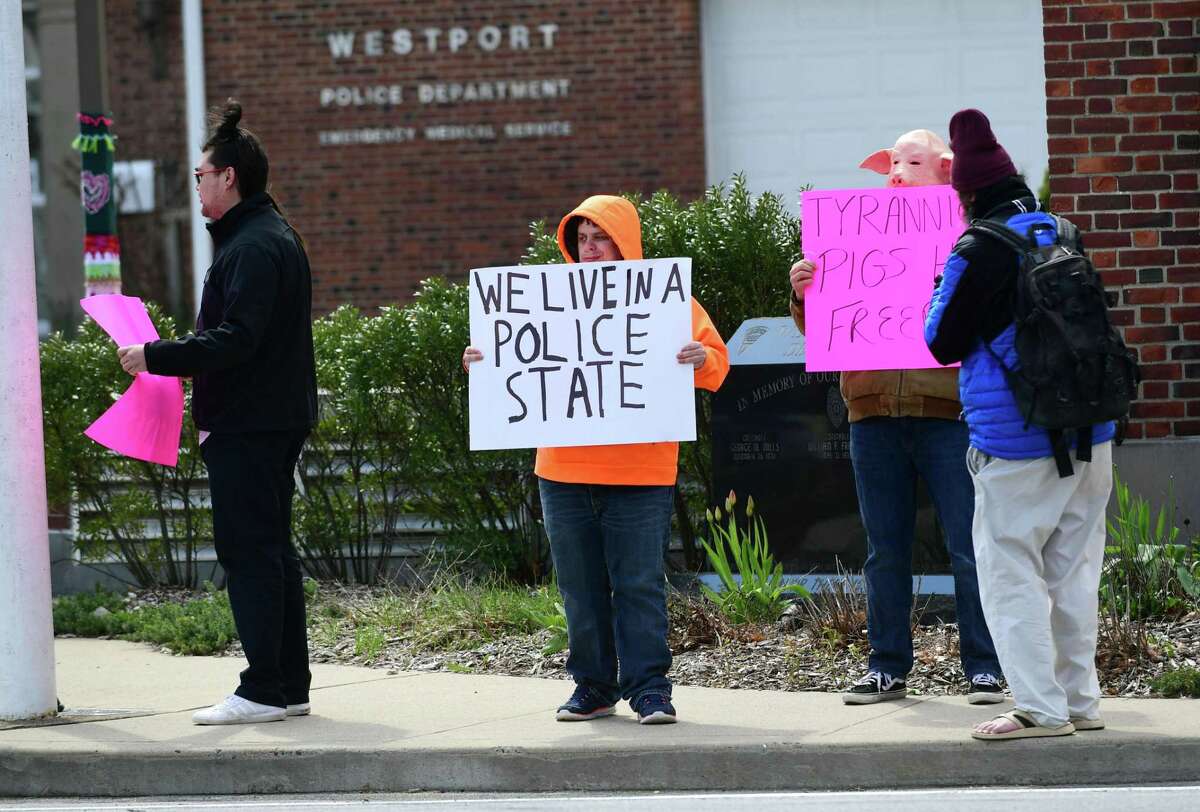 Protestors gather outisde the Westport Police Department Wednesday in Westport. The group was protesting the use of drones by the department to surveil residents diagnosed with coronavirus.