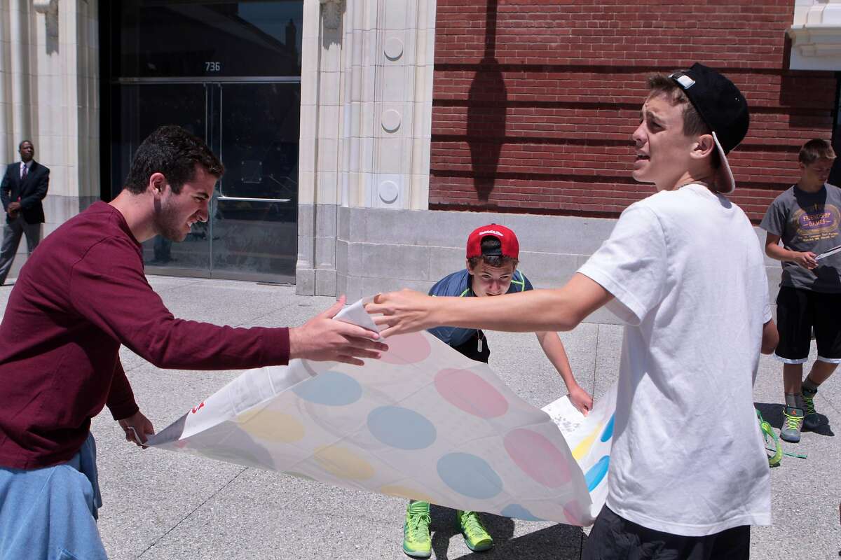 Teens from a Pennsylvania summer camp lay out the mat to play Twister during a lunchtime board games event at Jessie Square Plaza at the Contemporary Jewish Museum in San Francisco, Calif. on Tuesday, July 8, 2014. The event will take place on Tuesdays July 15, 22, 29 and August 12, 19 and 26 from noon to 1 p.m.