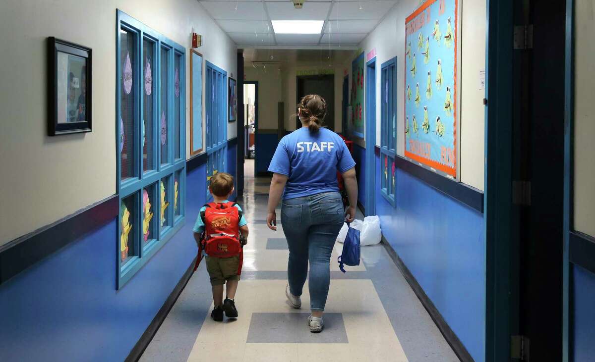 A YMCA staffer walks a child to his parent at the YMCA Labor Child Care Center on Wednesday, Apr. 22, 2020. A month after closing all its area branches and furloughing 1,679 full and part-time employees, the YMCA of Greater San Antonio is now taking the first tentative steps toward resuming normal activities. Besides recalling some laid-off employees, YMCA managers are now discussing how a reopening should happen. They are also making plans for summer programs that would normally include day camp and swimming lessons.