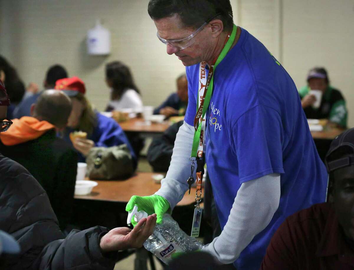 Alan Collins, a member of Haven for Hope Courtyard staff, administers hand sanitizer to clients. The shelter is taking precautions to keep the area and clients free of the coronavirus, on Wednesday, March 11, 2020.
