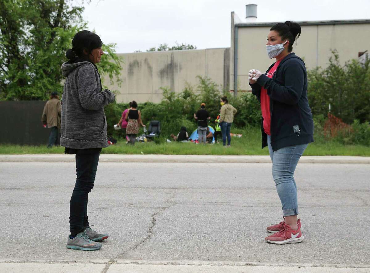 Valerie Salas, right, of Corazon Ministries chats with another woman while others give meals to the homeless on April 2.