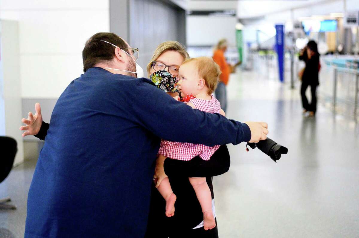 UCSF clinical nurse Ashley Batchelder hugs her husband Nathan Batchelder and daughter Cathering Batchelder, 16 months, at San Francisco International Airport while en route to Navajo Nation to treat COVID-19 patients on Wednesday, April 22, 2020. A group of UCSF staff including 14 nurses and seven doctors volunteered for the assignment in Navajo Nation hospitals in Arizona and New Mexico.