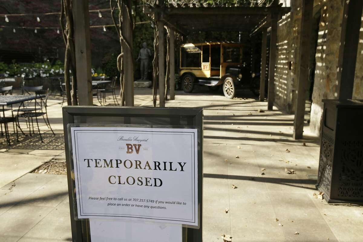 In this photo taken Thursday, March 19, 2020, a temporarily closed sign is posted outside the entrance to the Georges De Latour Reserve Tasting Room at the Beaulieu Vineyard winery in Rutherfod, Calif. Wineries in the Napa Valley are closed due to coronavirus restrictions expect for production, but some allow customers to pick up shipments of wine and for direct purchases. (AP Photo/Eric Risberg)