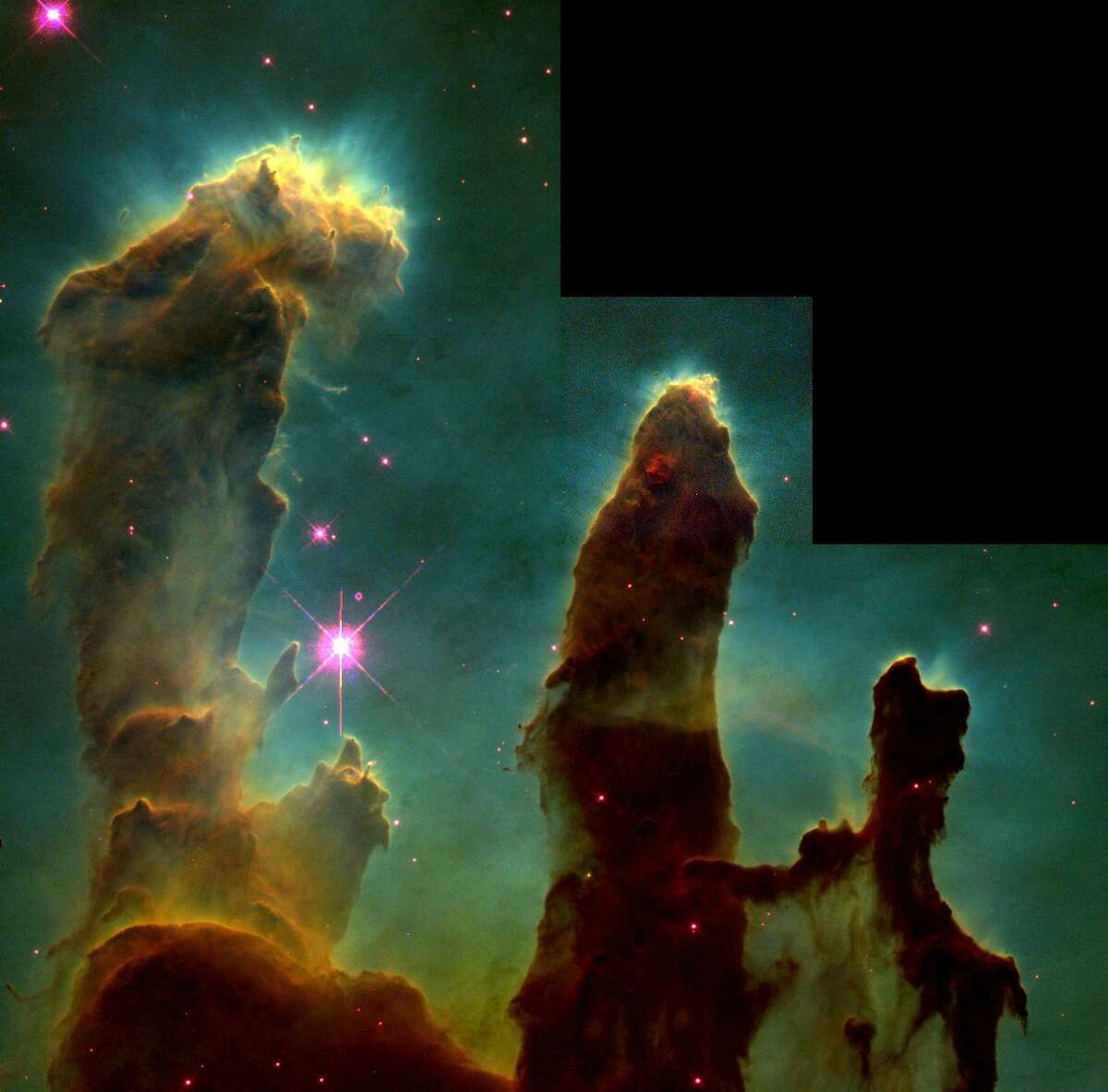 This composite file photo released by NASA Nov. 2, 1995, taken by the Hubble Space Telescope on April 1, 1995, shows dark pillar-like structures that are actually columns of cool interstellar hydrogen gas and dust and also incubators of new stars in the Eagle Nebula. The color image is constructed from three separate images taken in the light from different types of atoms. Red shows emission from sulfur atoms, green from hydrogen, and blue from oxygen, according to NASA, which calls the photo Pillars of Creation. (AP Photo/NASA, File)
