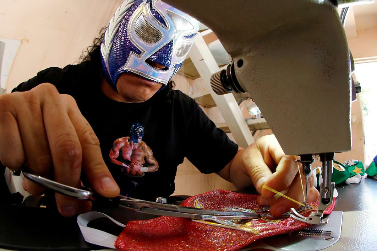 TORREON, MEXICO - APRIL 21: Mexican Lucha Libre wrestler, 'El Hijo del Soberano' makes face masks on April 21, 2020 in Torreon, Mexico. Due to the COVID-19 pandemic, 'El Hijo del Soberano' turned to produce themed protective masks in a studio with his family. (Photo by Armando Marin/Jam Media/Getty Images)