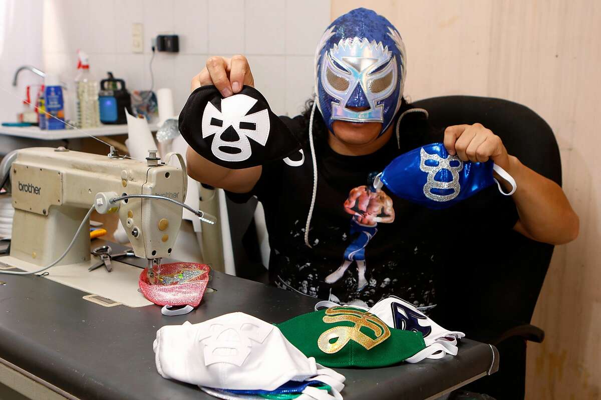 TORREON, MEXICO - APRIL 21: Mexican Lucha Libre wrestler, 'El Hijo del Soberano' shows a 'Blue Demon' and "El Espanto" wrestlers face masks on April 21, 2020 in Torreon, Mexico. Due to the COVID-19 pandemic, 'El Hijo del Soberano' turned to produce themed protective masks in a studio with his family. (Photo by Armando Marin/Jam Media/Getty Images)