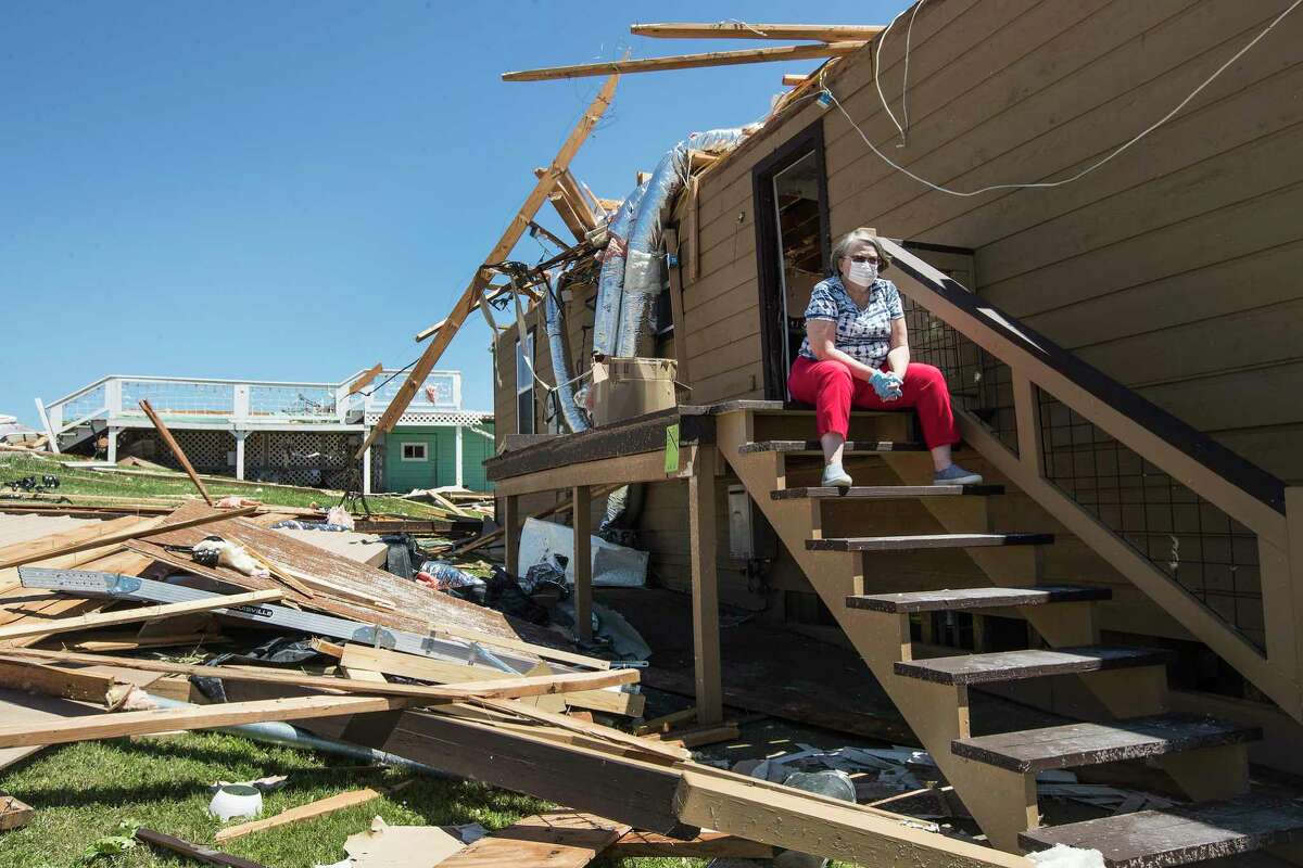 Loretta Moehle takes a break on the steps of a friends house on Thursday, April 23, 2020, after a tornado ripped through the area and destroyed several homes in Onalaska, Texas. Several people were killed and up to 30 people were injured Wednesday as a tornado ripped through the small East Texas city, about 85 miles north of Houston.