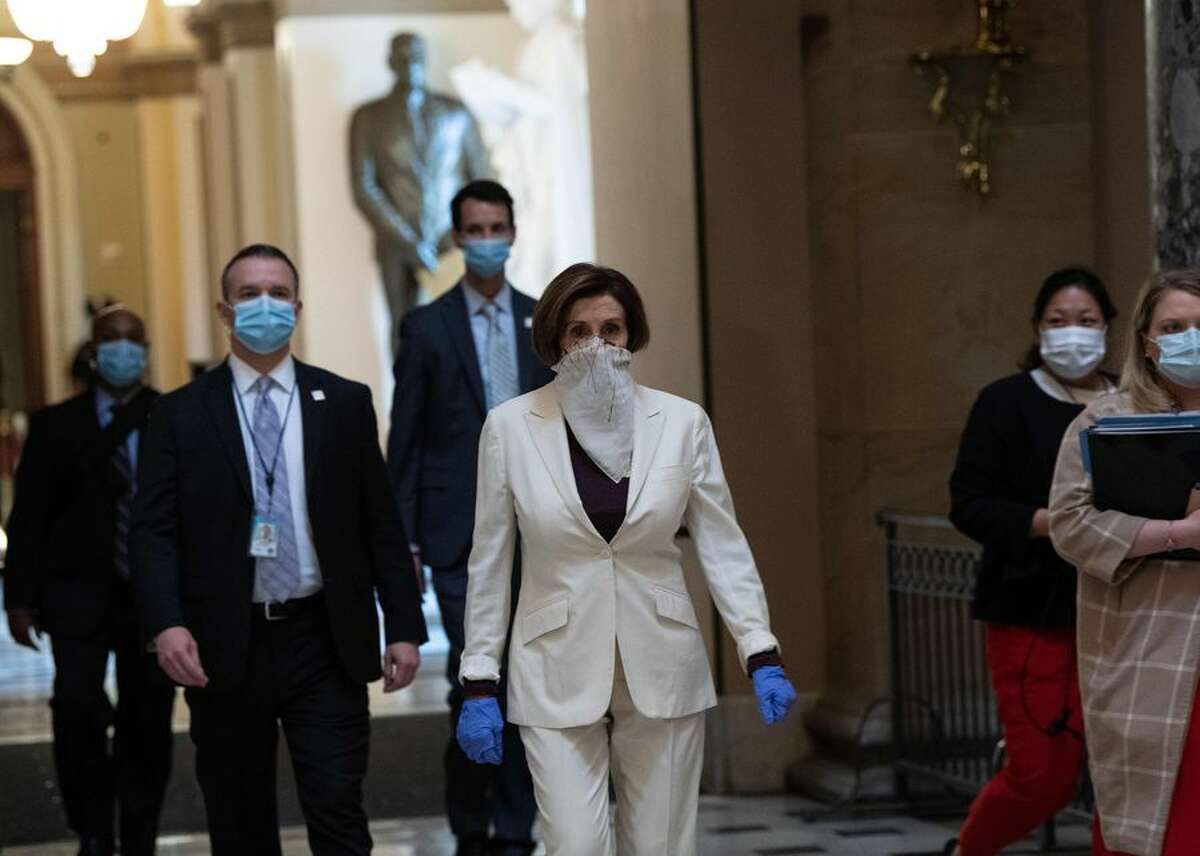 Speaker of the House Nancy Pelosi (center) walks out of the chamber of the US House of Representatives after debate April 23 on a $484 billion relief package. The bill would provide funds for the Paycheck Protection Program, along with other small-business loans, emergency relief for hospitals and money for coronavirus testing.