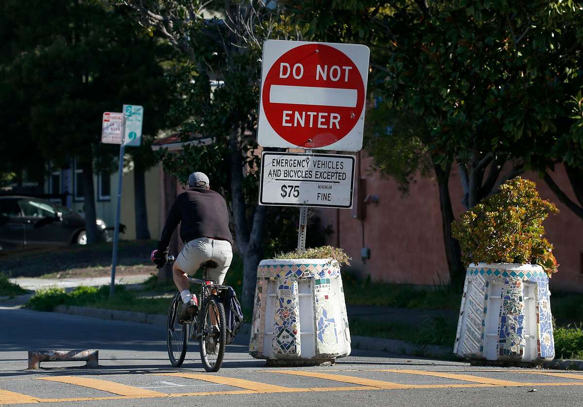 A bicyclist rides past barricades that prevent traffic from entering northbound Fulton Street from Ashby Avenue in Berkeley, Calif. on Wednesday, April 22, 2020.