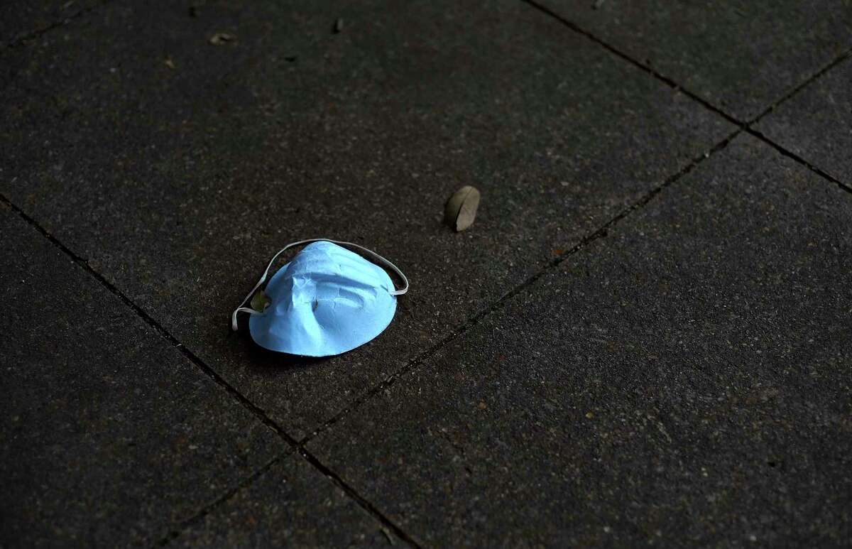 A face mask is left on the ground at the Texas Medical Center.